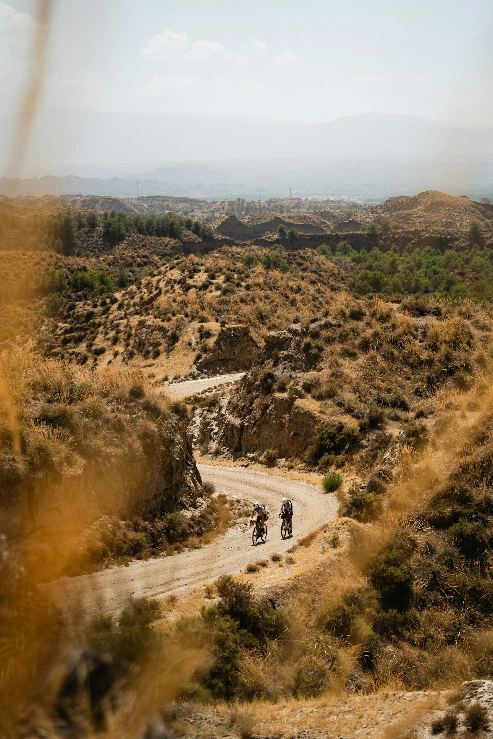 two bike riders in the desert riding gravel