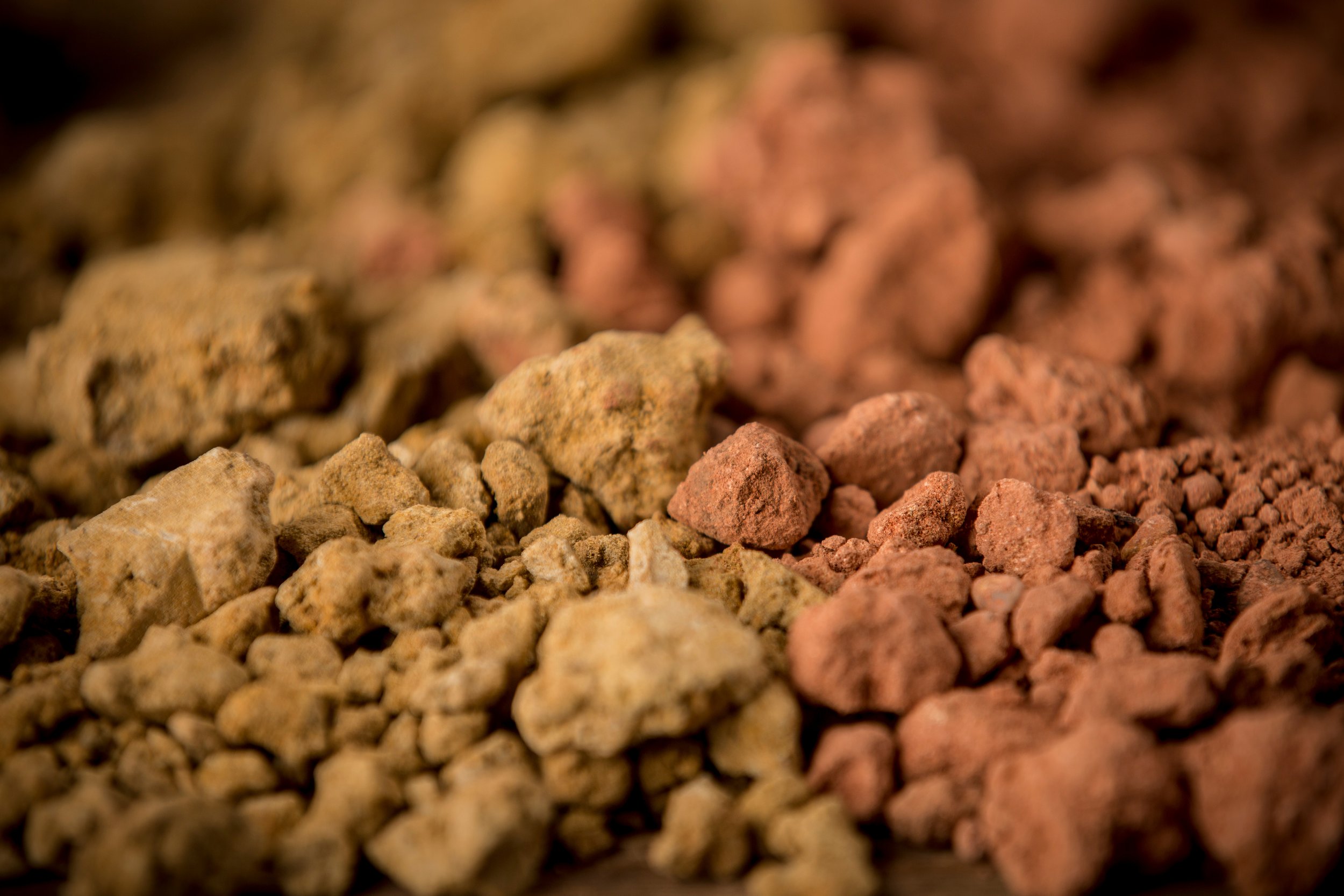 Close-up of small rocks or mineral stones in various shades of tan, pink, and brown.
