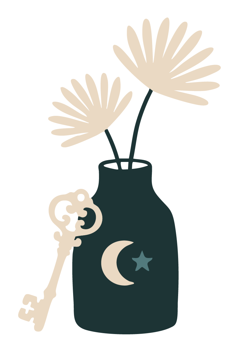 A dark-colored vase with a star and moon design, containing two cream-colored tropical flowers, and a vintage key hanging from the side of the vase.
