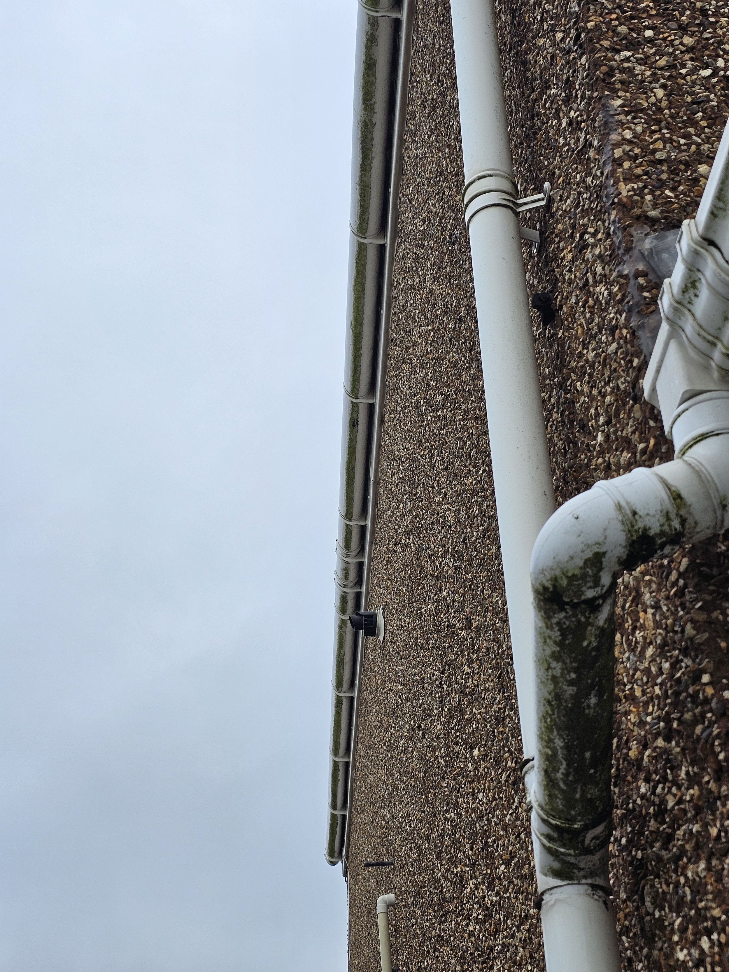 White PVC pipes on a gravel rooftop with a foggy sky in the background.