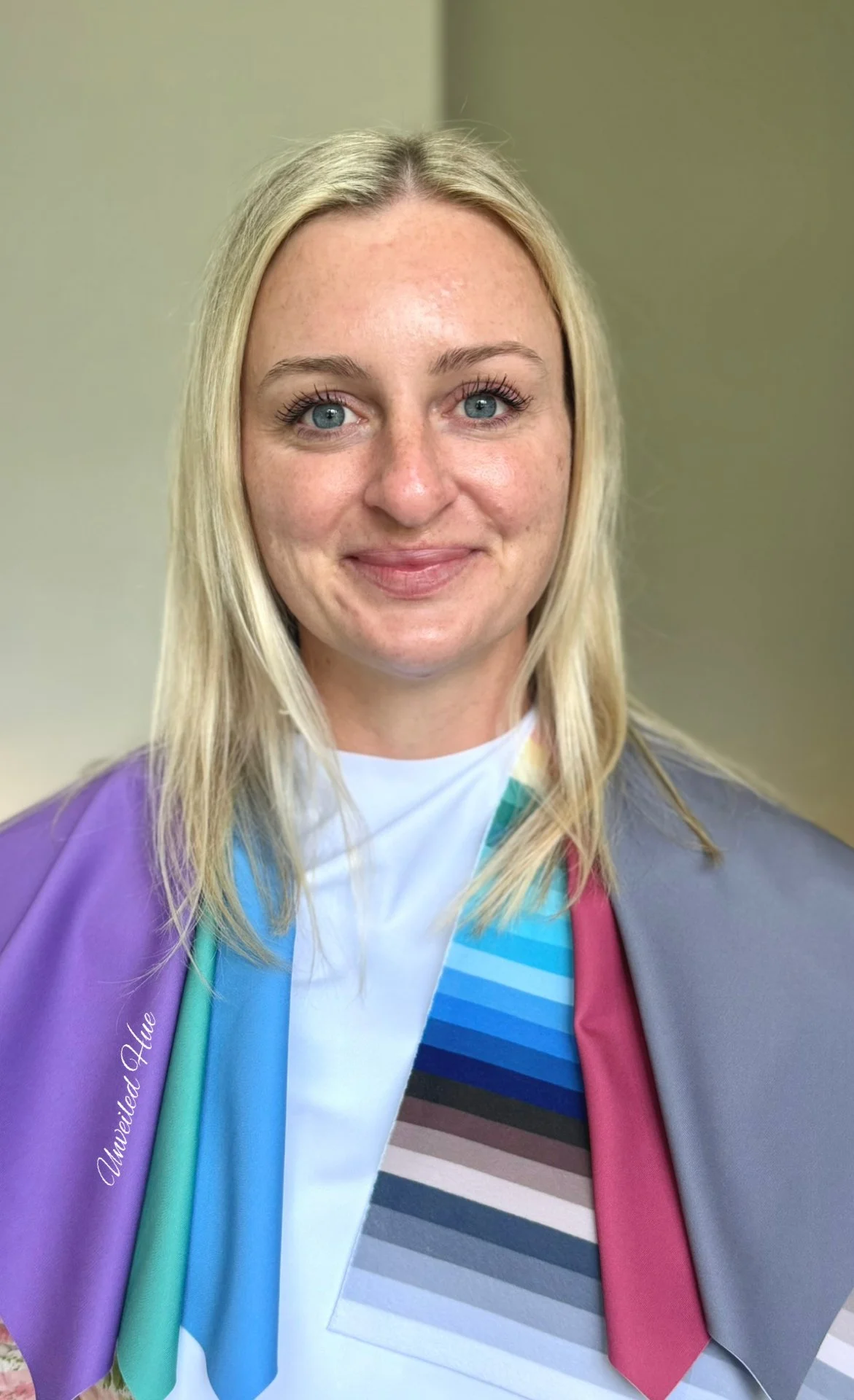 A female professional with blonde hair and blue eyes, wearing cool summer color analysis drapes, smiling at the camera in Hampton Roads, VA