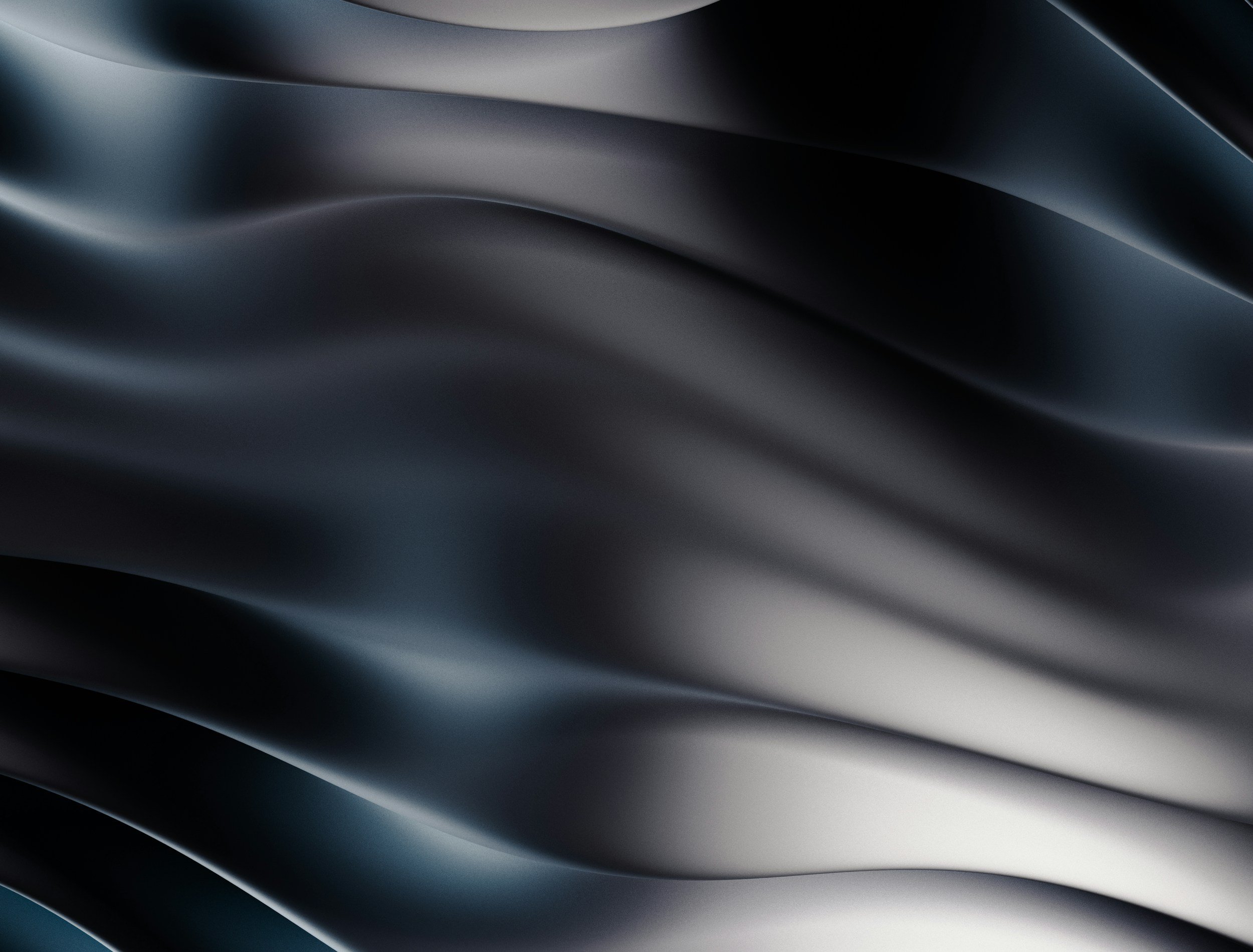 Une surface noire et argentée avec des courbes fluides et brillantes, évoquant du métal ou un matériau de haute technologie.