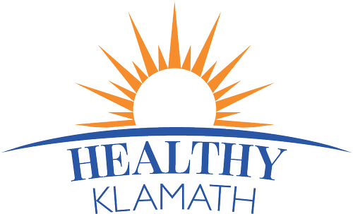Sun rising over blue waves with the text 'Healthy Klamath' underneath.