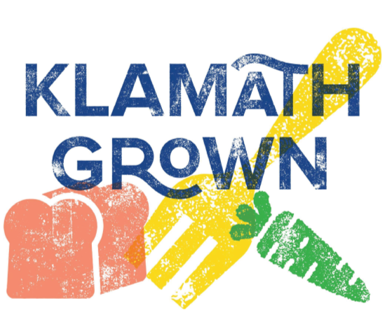 Graphic with text 'Klamath Grown' featuring a yellow garden trowel, a green carrot, and an orange fist.