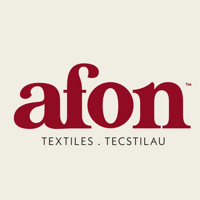 Logo for Aton Textiles with the word 'aton' in large, red letters and 'TEXTILES . TECSTILAU' in smaller, black letters below.