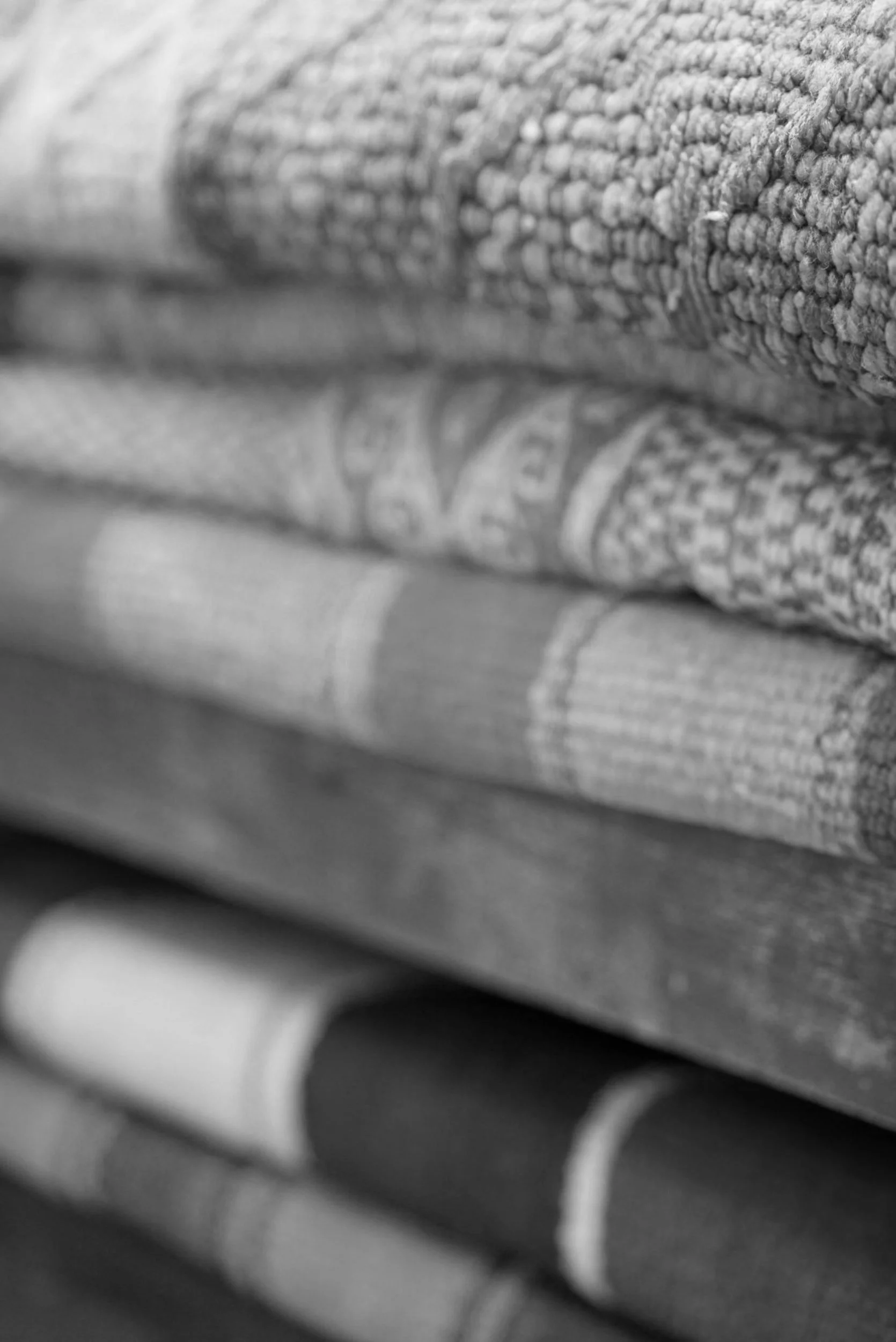 Stacked rolled-up newspapers or magazines in black and white.