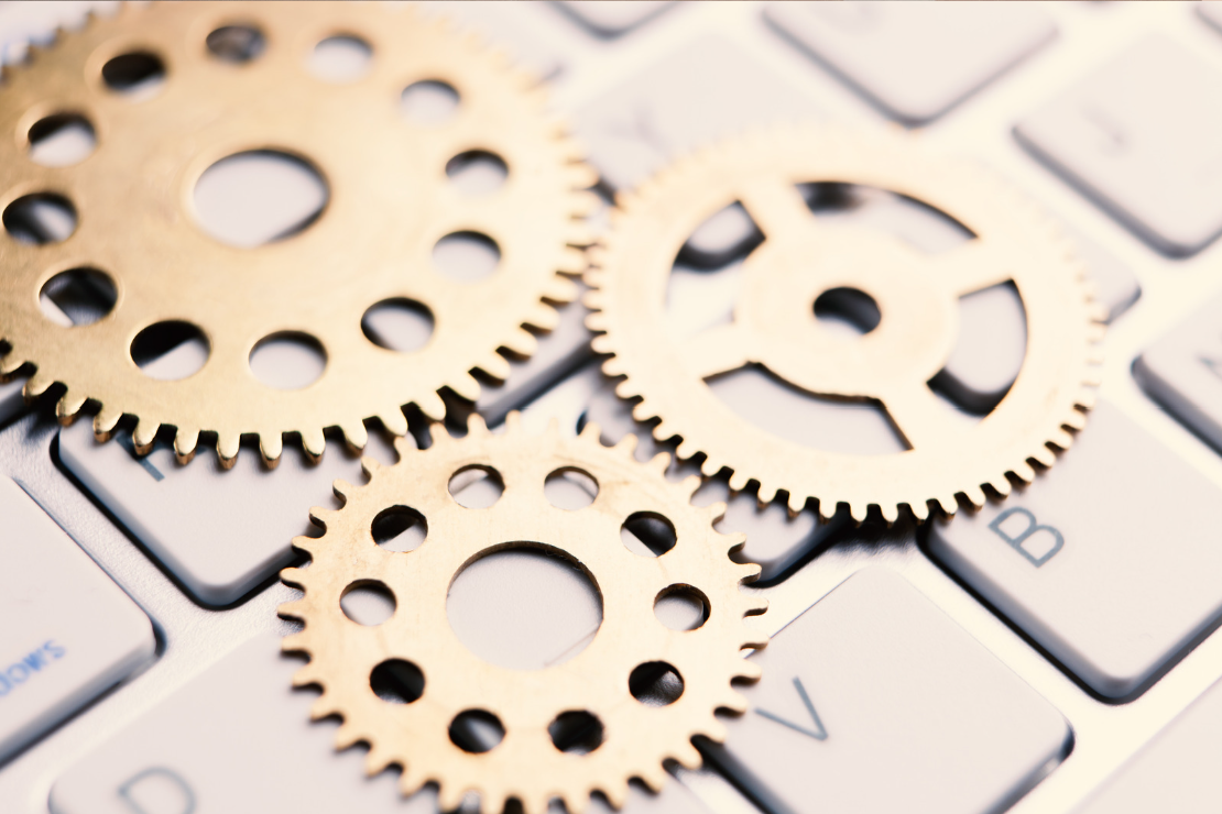 Three small brass gears placed on a computer keyboard.
