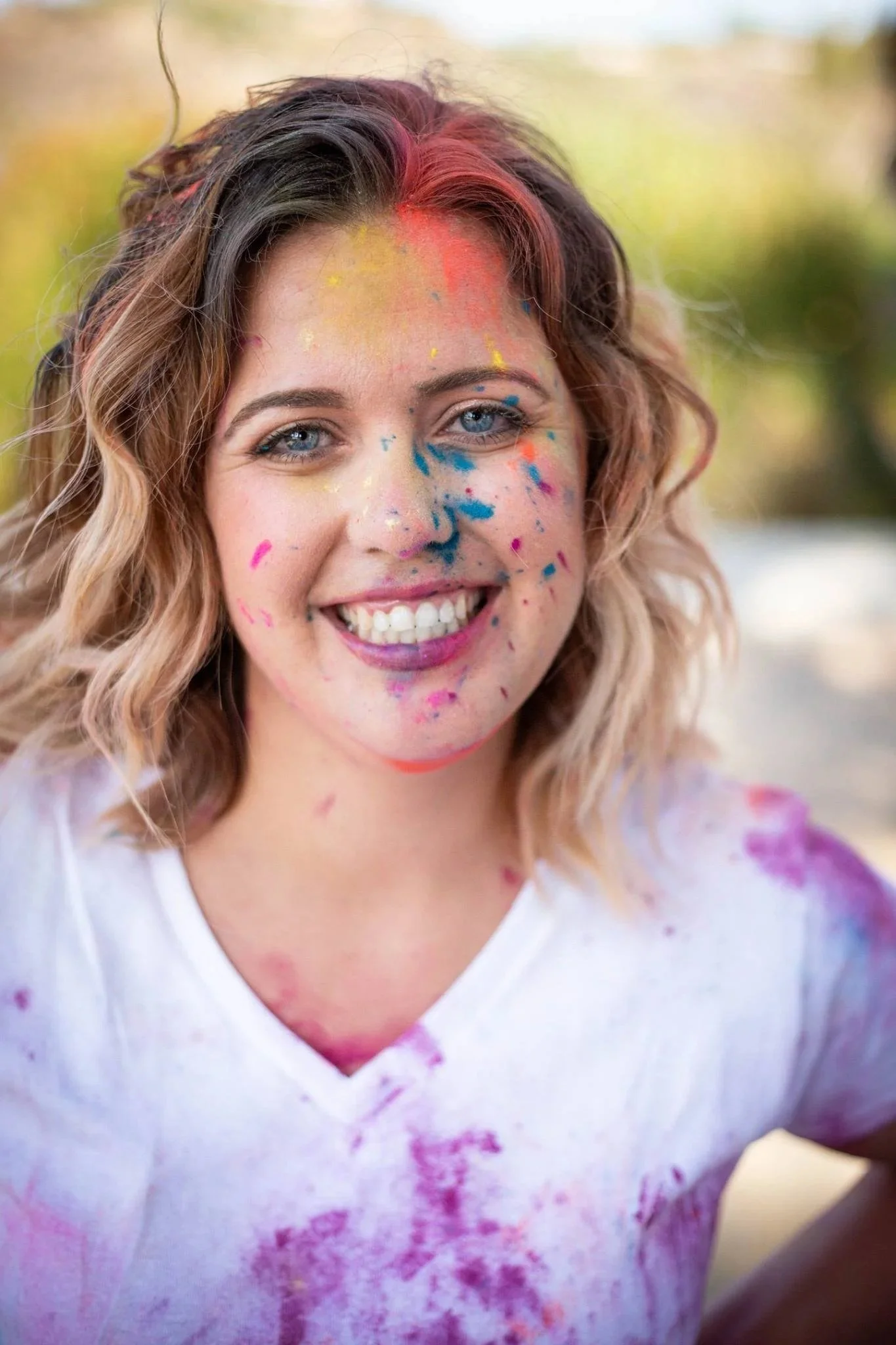 Headshot of Matti Mattilyn Millman CEO, Therapist, Owner Connective Healing Therapy Smiling with Vibrant Color Powder on her Face and Neck