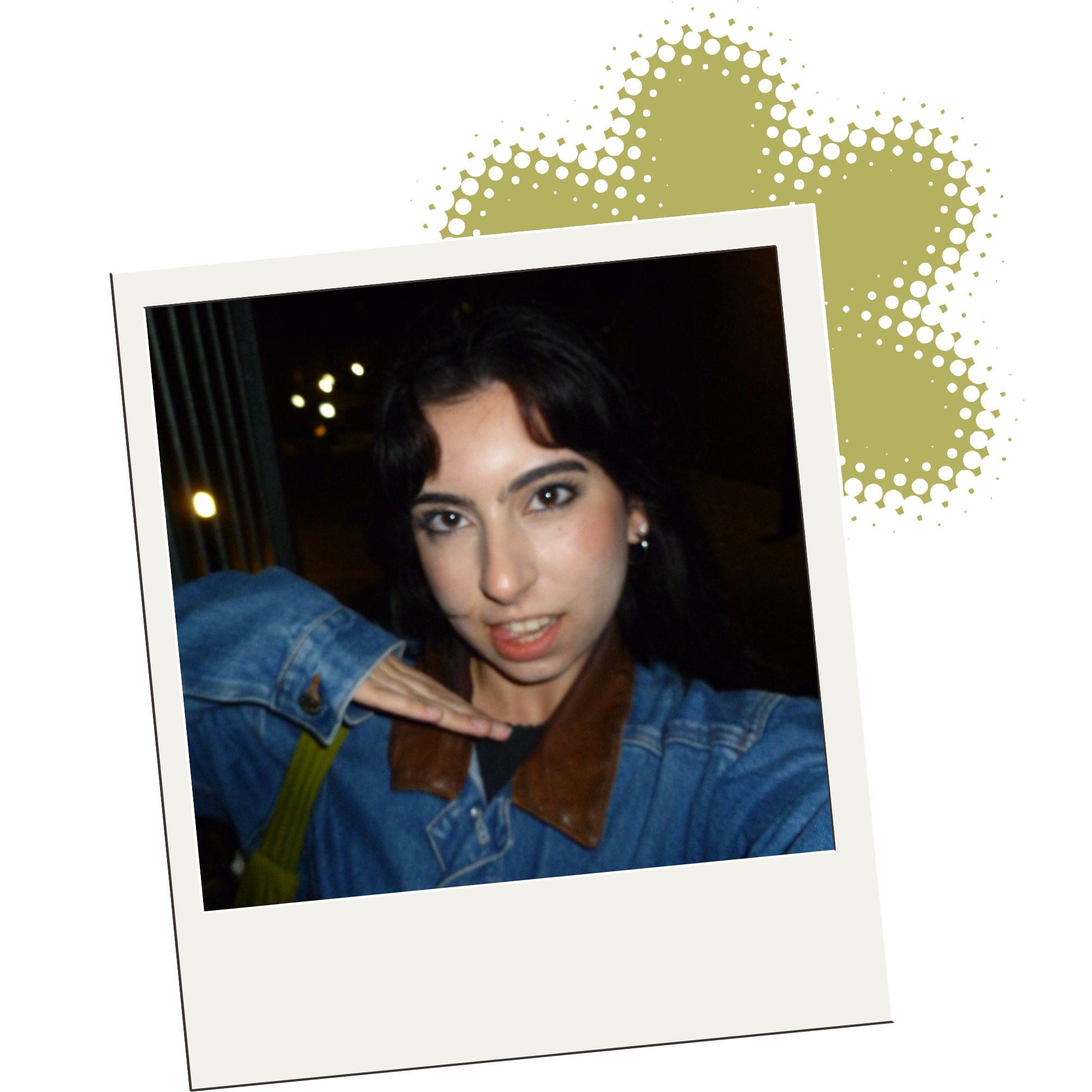 Close-up of a printed photograph of a woman with dark hair, wearing a blue denim jacket, with bokeh lights in the background.