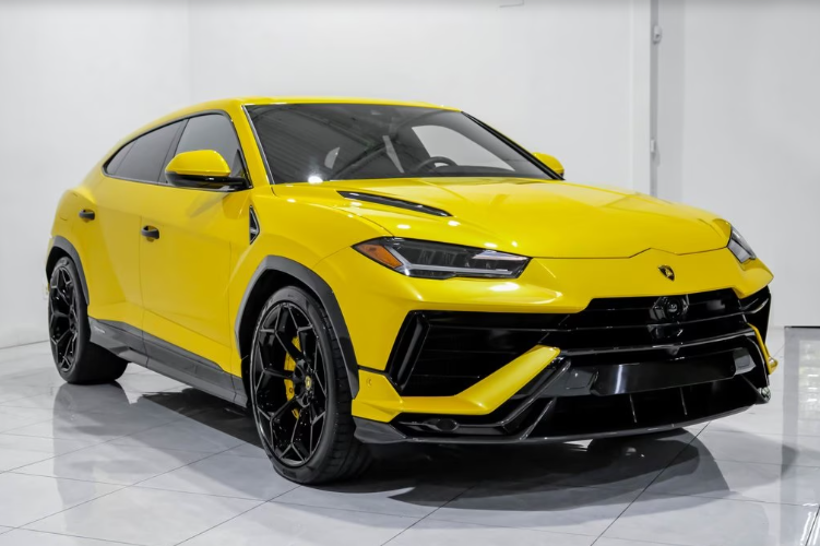 Yellow Lamborghini SUV parked indoors on a shiny floor.