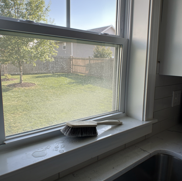 Gritty dirt packed along bottom window frame joint