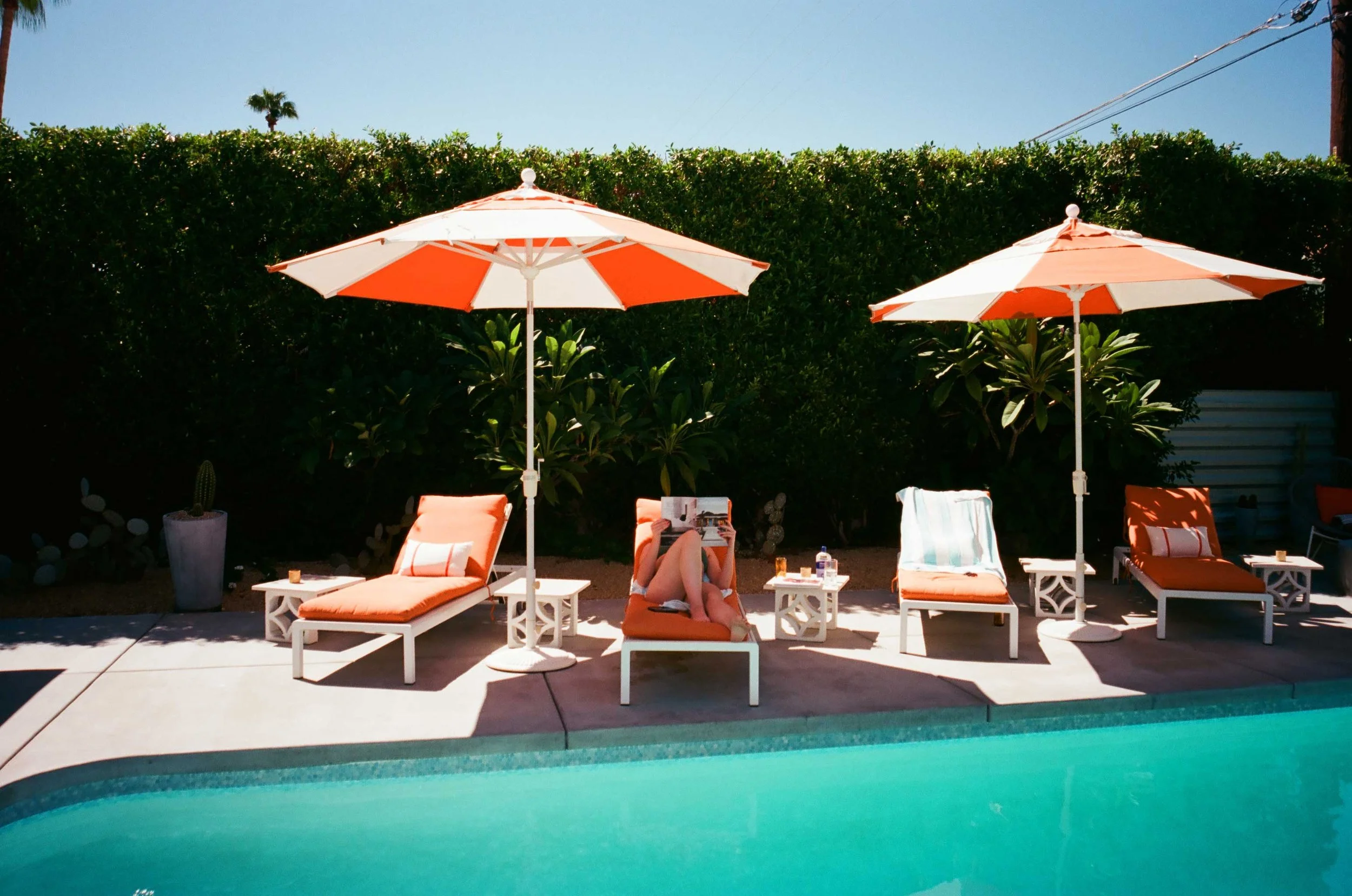 Woman lounging by the pool reading a book