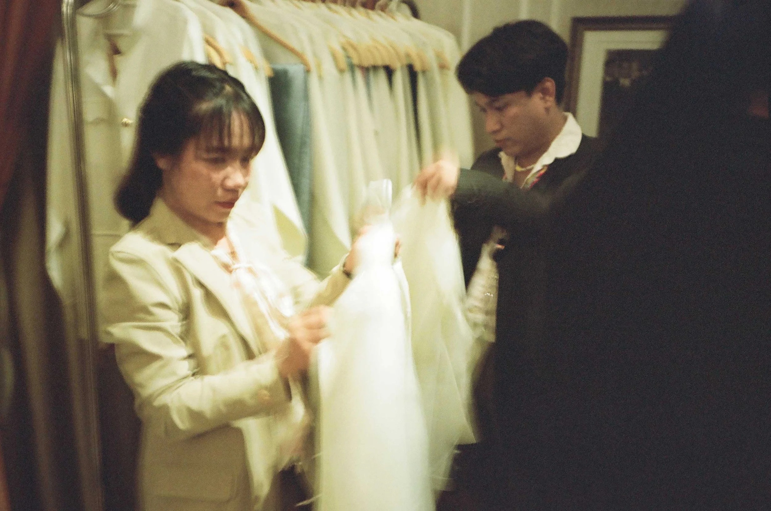 A photo of two Thai people gathering garments for a wedding.