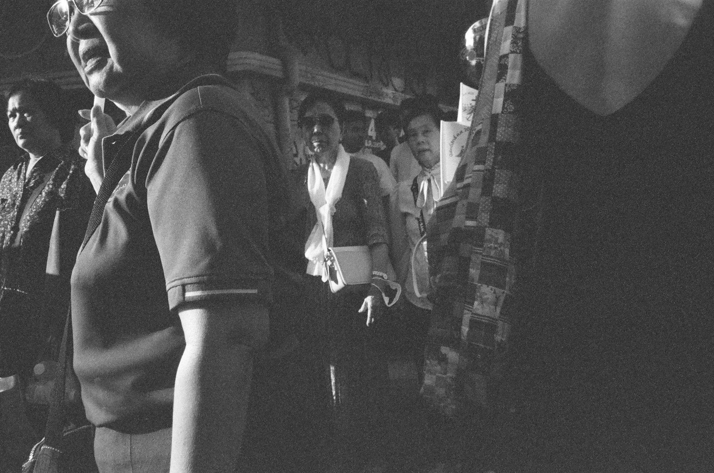 A candid photo of old women on a sidewalk in the early evening in Bangkok