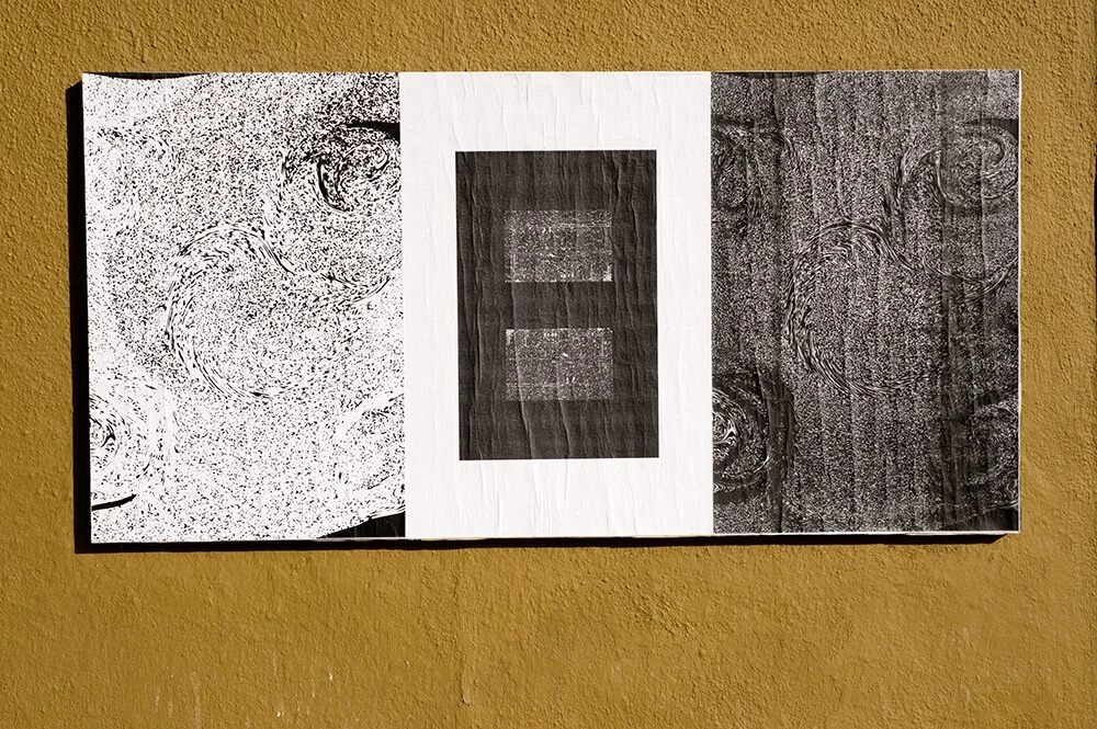 A photograph of digital artwork wheat pasted to a wall