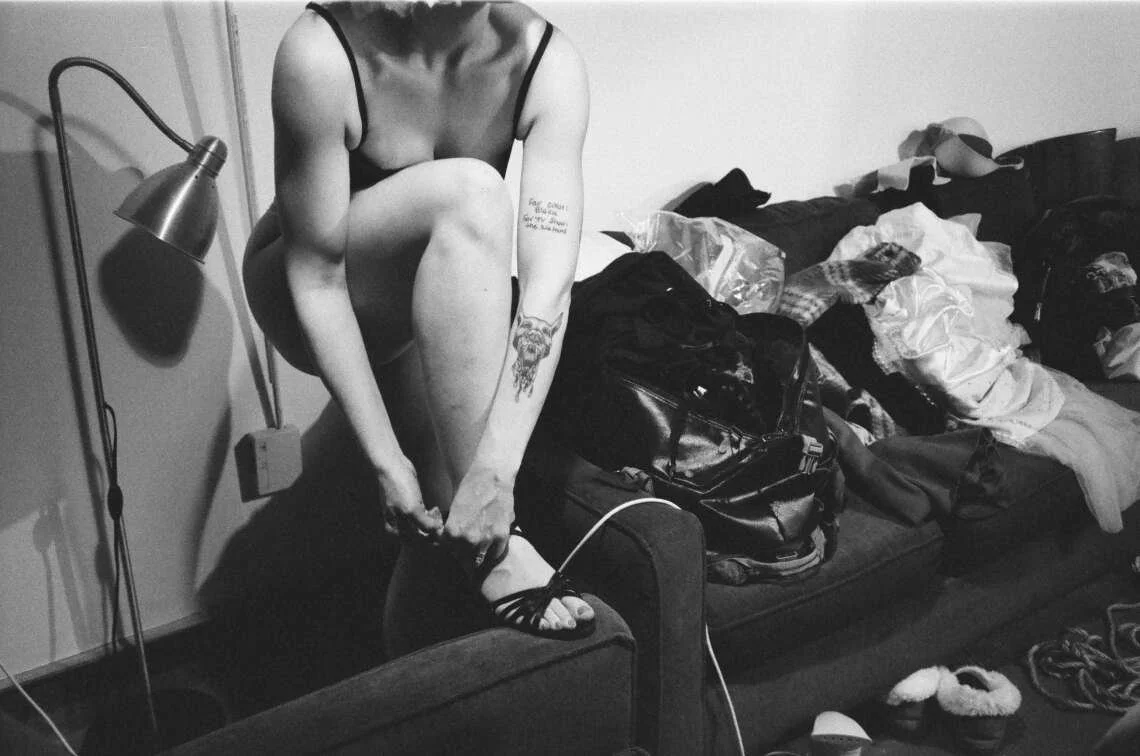 Person putting on shoes against a sofa.