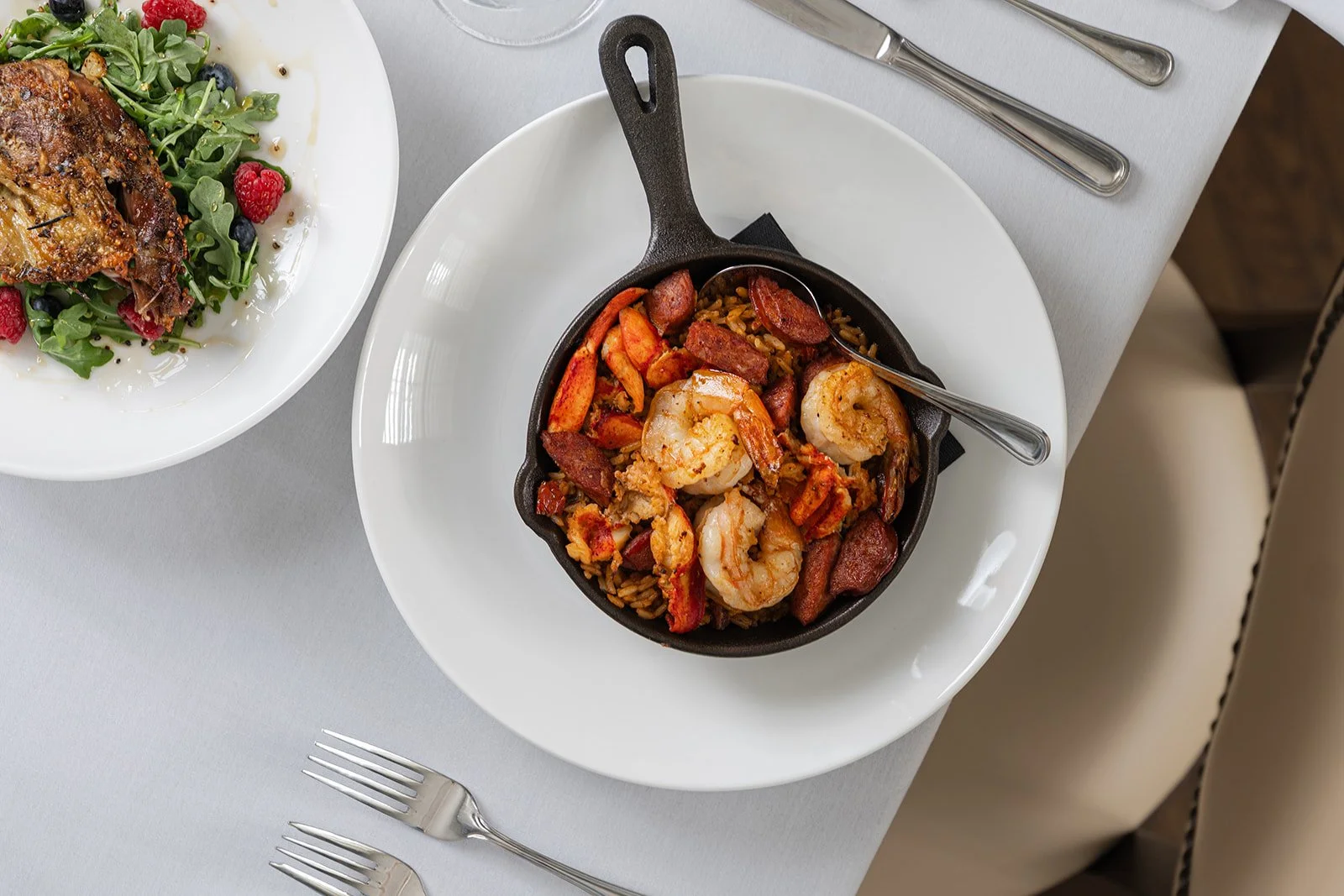 Carlisle's Restaurant in Hotel Everett | Boutique Hotel in Winnsboro, SC, historic hotel | A white plate with a small cast iron skillet containing shrimp, sausage, and rice.