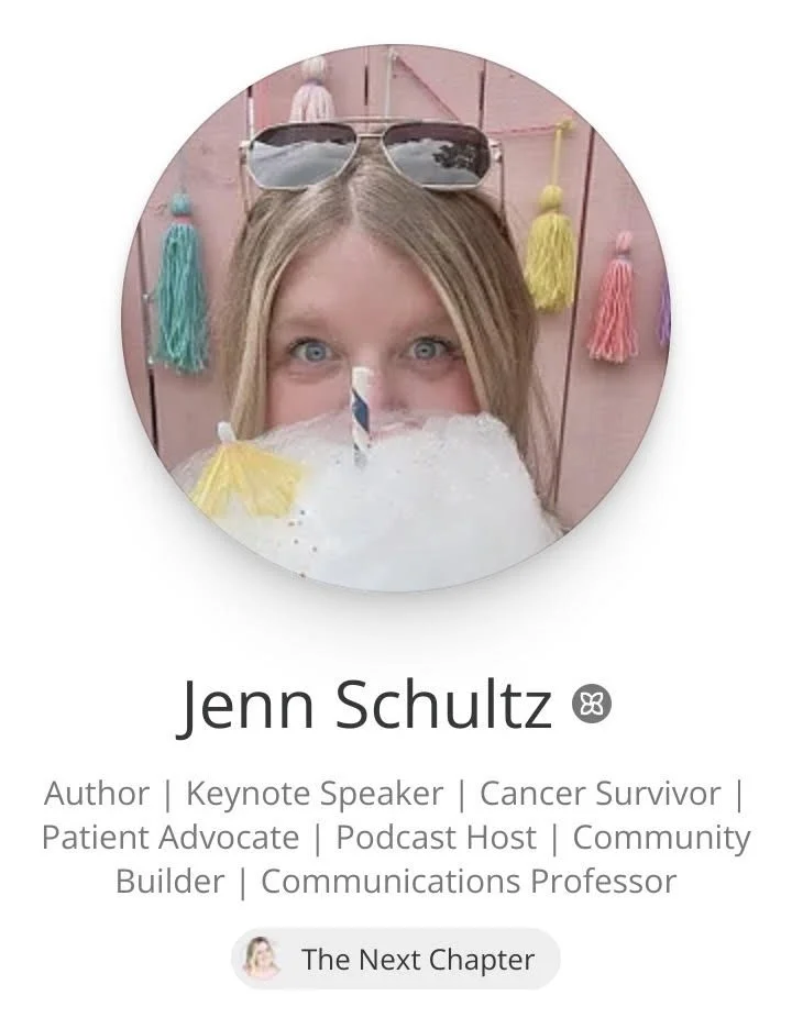 Jenn Patrice Schultz, a woman with blonde hair and blue eyes wearing sunglasses on her head and holding cotton candy, smiling and standing in front of a pink wall decorated with colorful tassels.