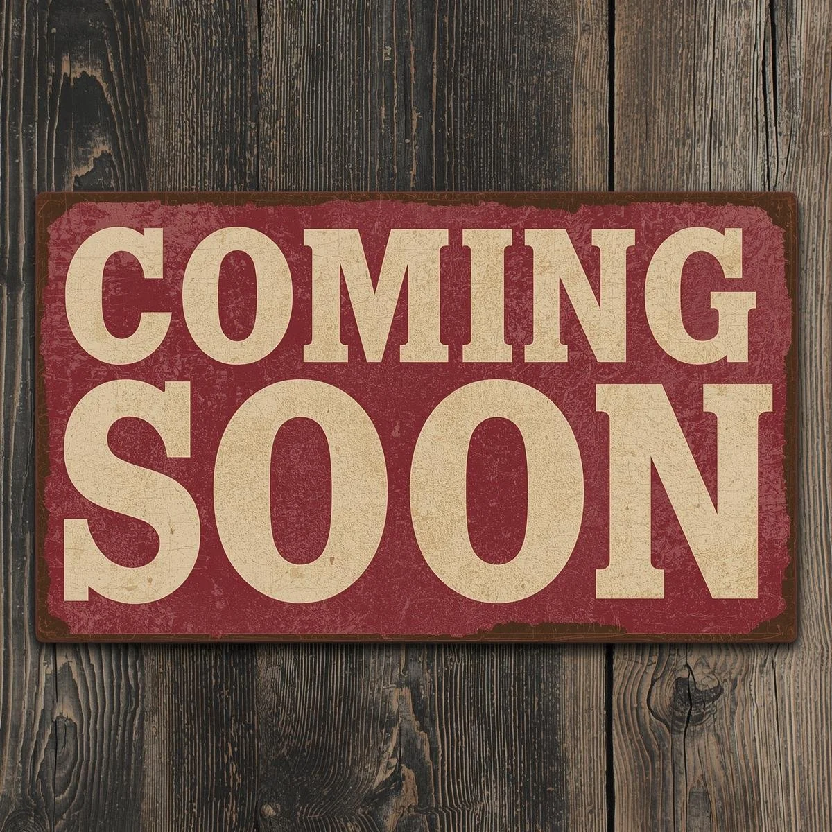 A vintage-style sign with the words "Coming Soon" in large, bold letters, placed on a wooden surface.