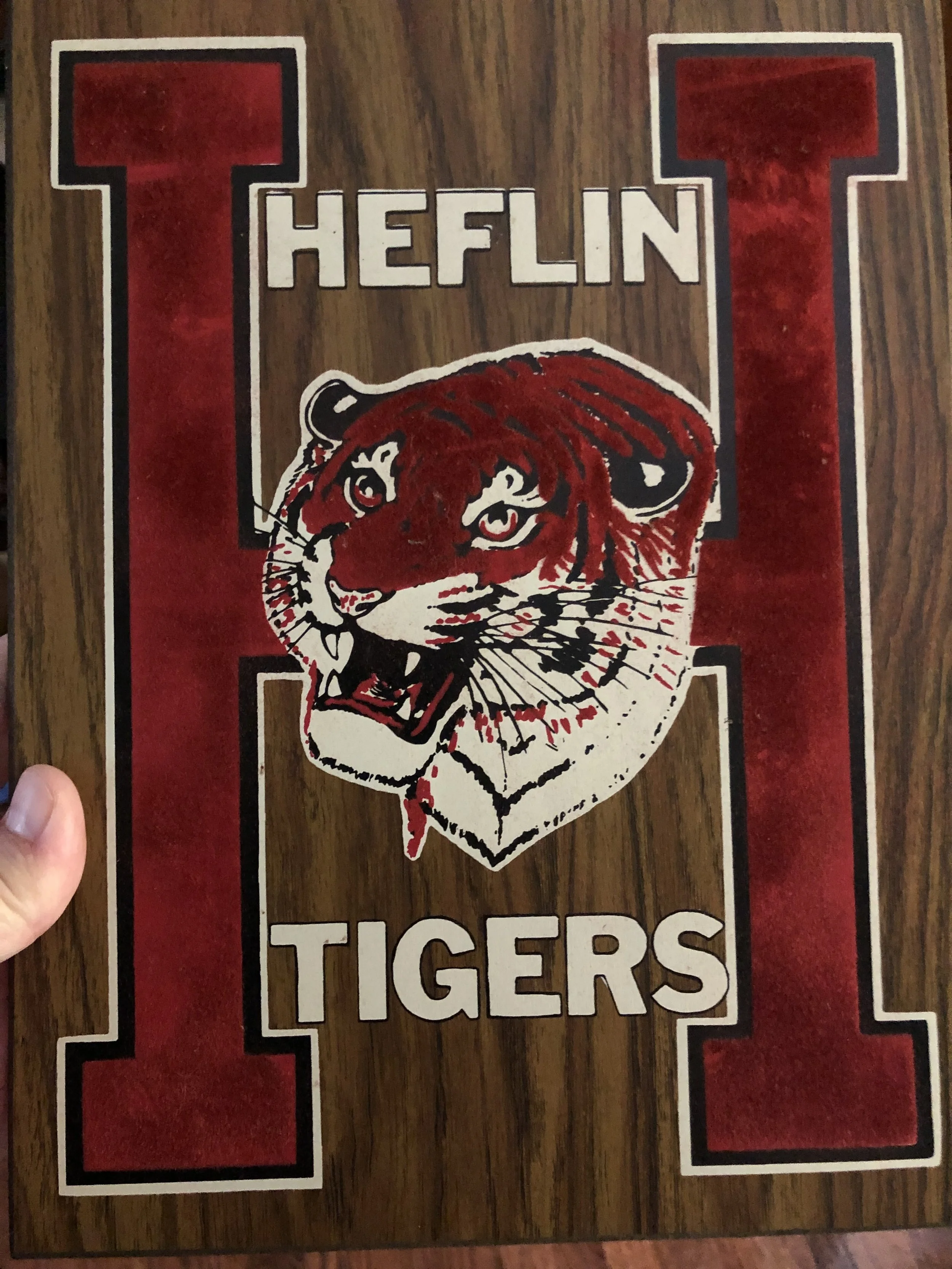 A wooden plaque with a red velvet letter H reading Heflin Tigers, featuring an illustrated tiger head in red, white, and black.