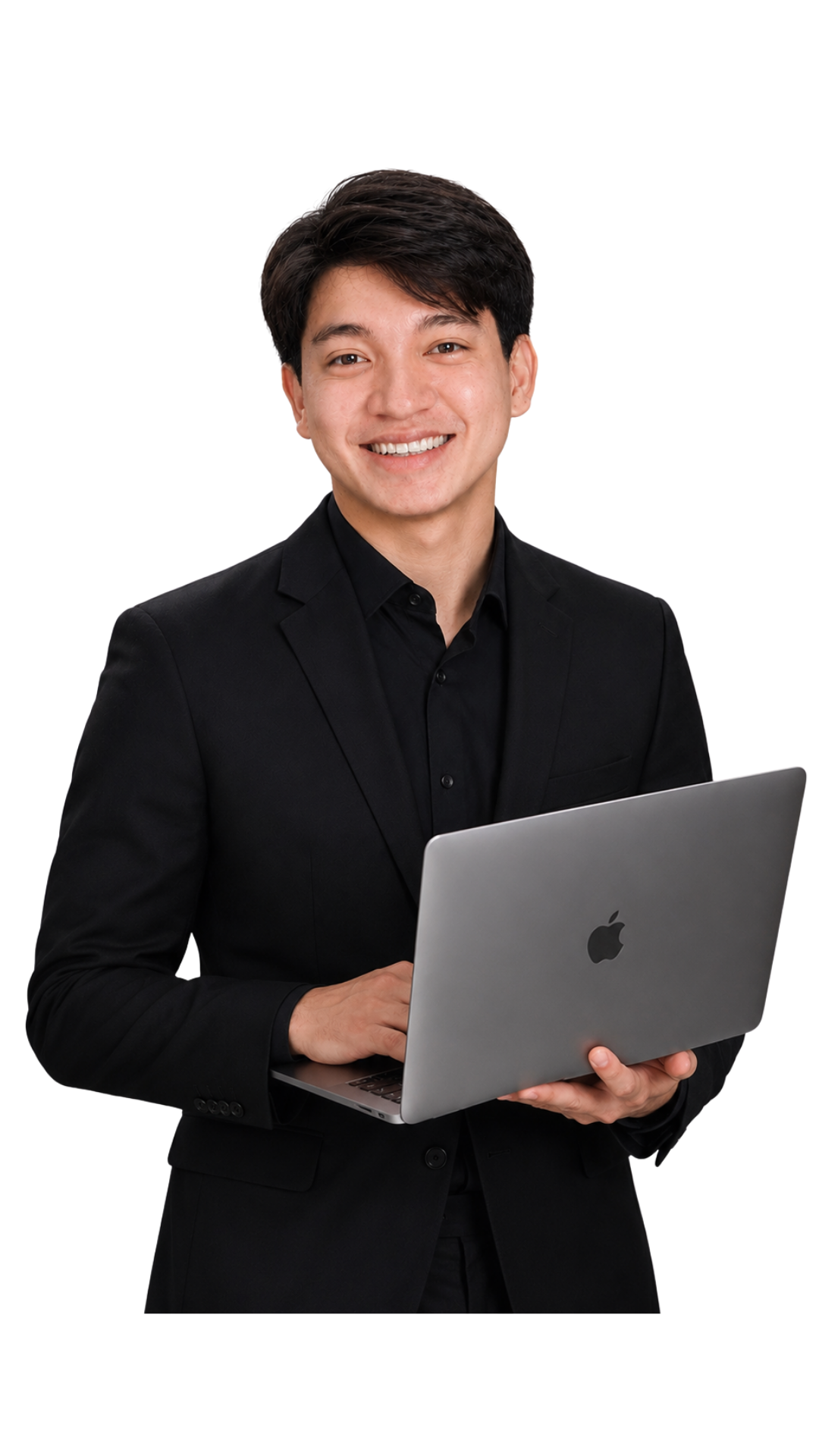 A smiling young man in a black suit holding an open silver MacBook laptop.
