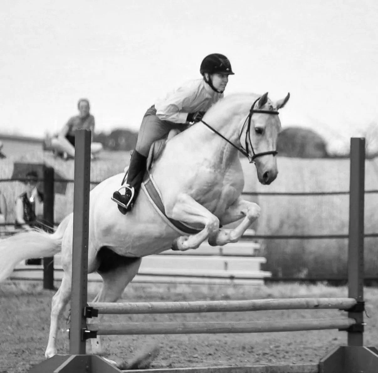 A person riding a horse jumps over a hurdle in an equestrian event.
