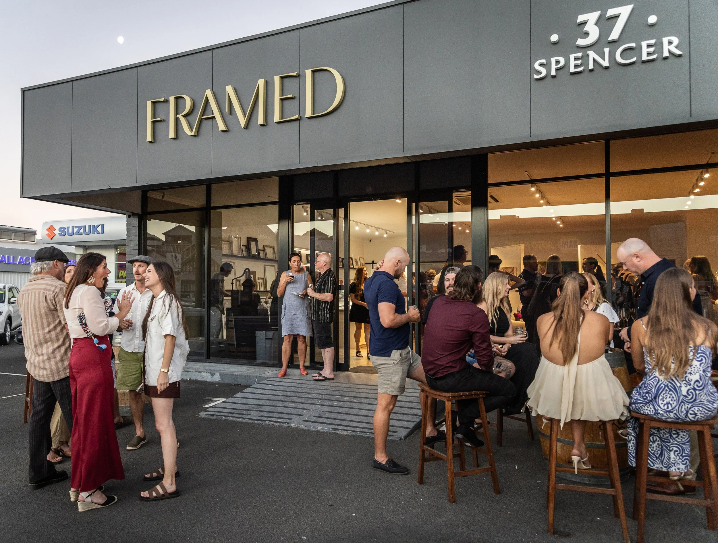 People gathered outside Framed at 37 Spencer Street in Bunbury, Western Australia, during a creative community event. Guests socialising outside the custom framing, fine art printing, and gallery space at dusk.