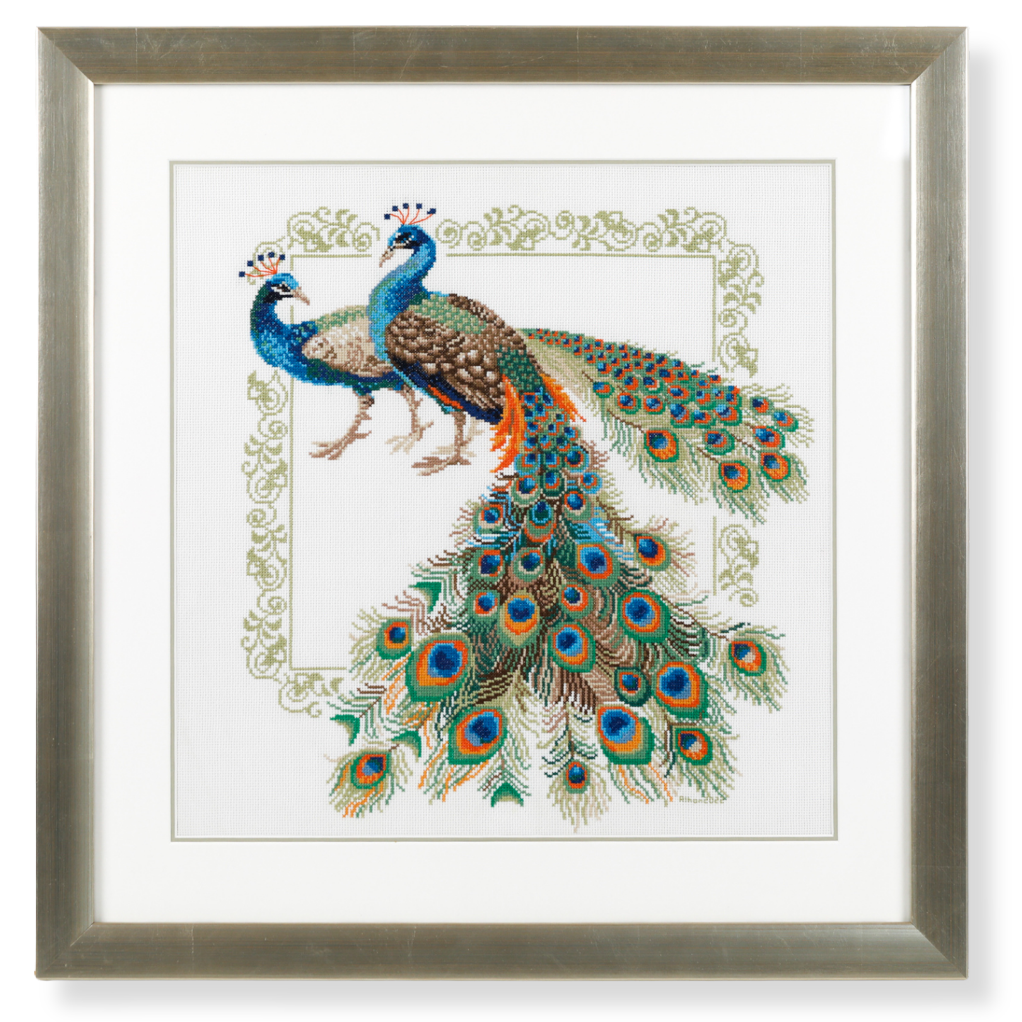 Custom framed peacock cross stitch embroidery artwork featuring intricate feather detailing and a classic silver frame. 