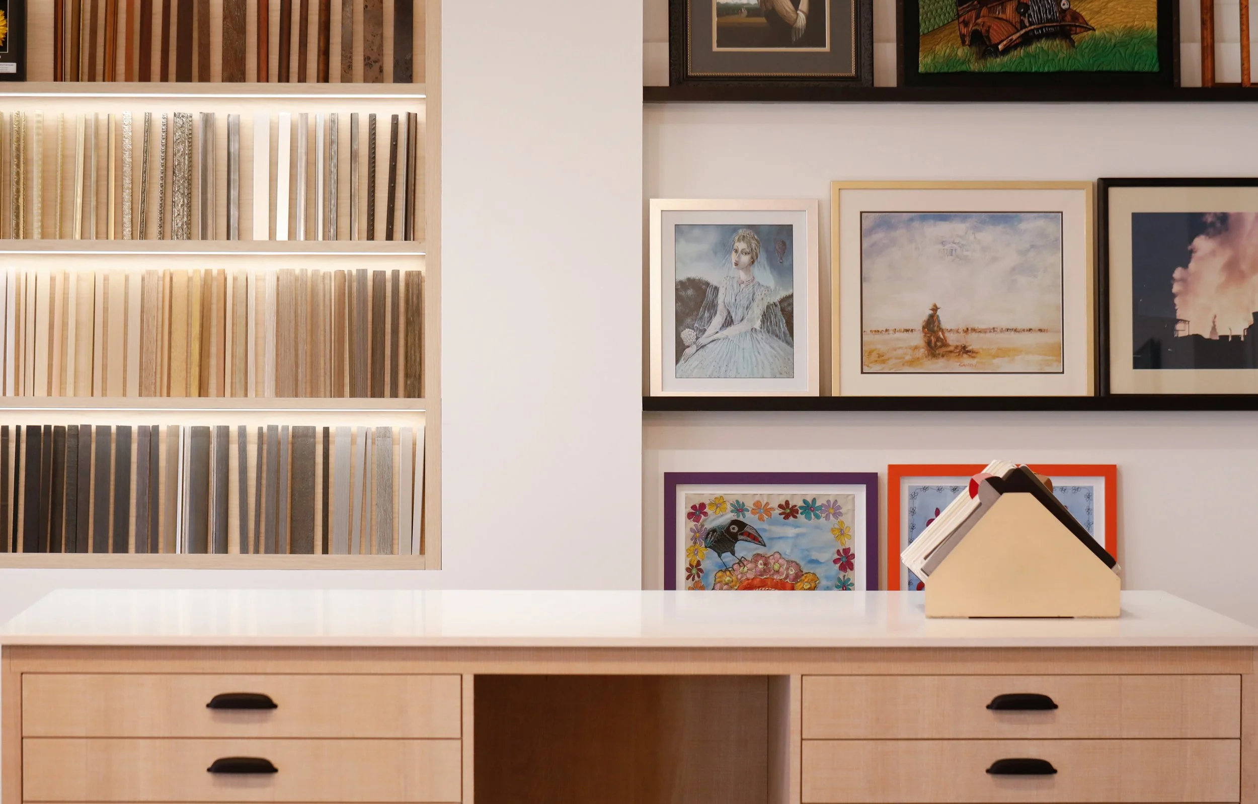 Modern custom framing consultation space at Framed, featuring a moulding display wall and gallery-style framed artwork and a new design experience.
