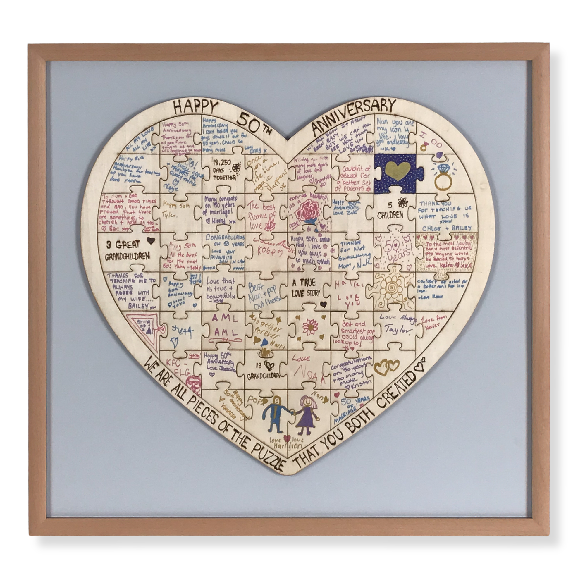 Custom framed heart-shaped anniversary puzzle featuring handwritten messages and family memories celebrating a 50th wedding anniversary.