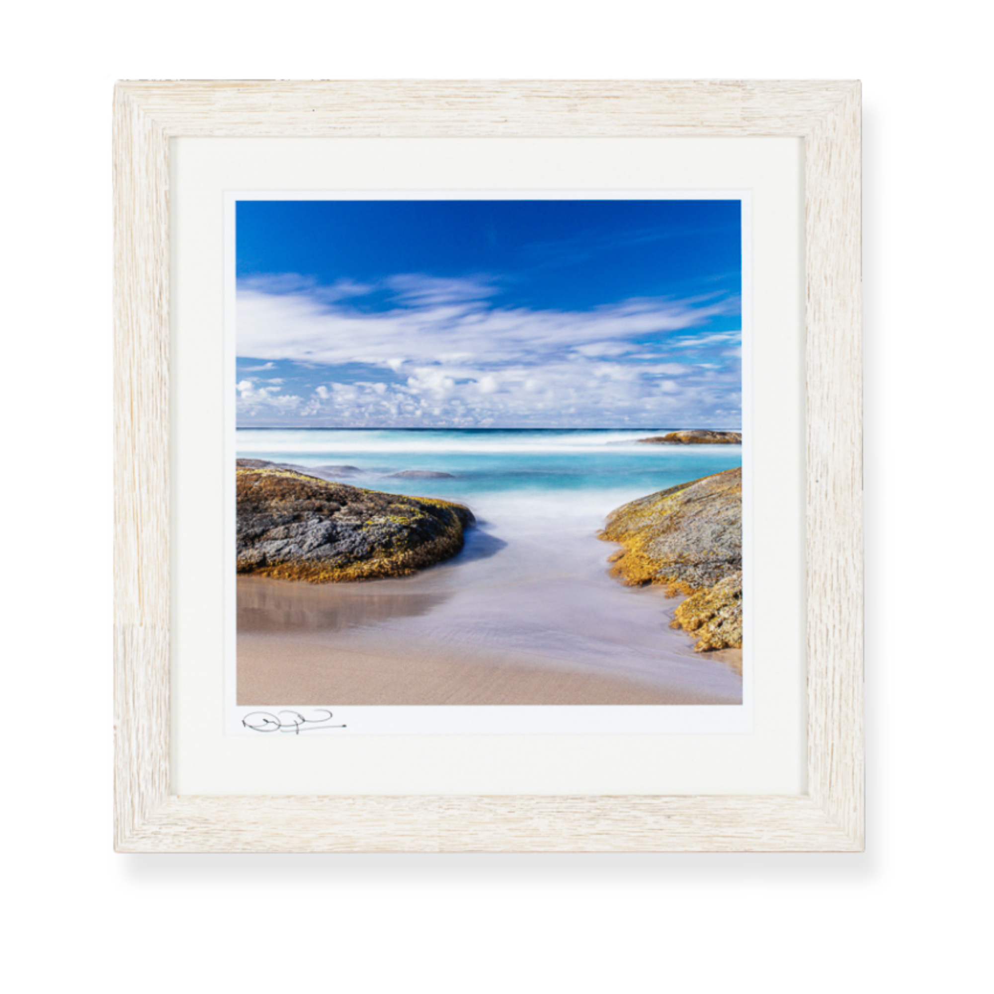 Framed coastal landscape print featuring ocean views and beach scenery in a white timber frame.