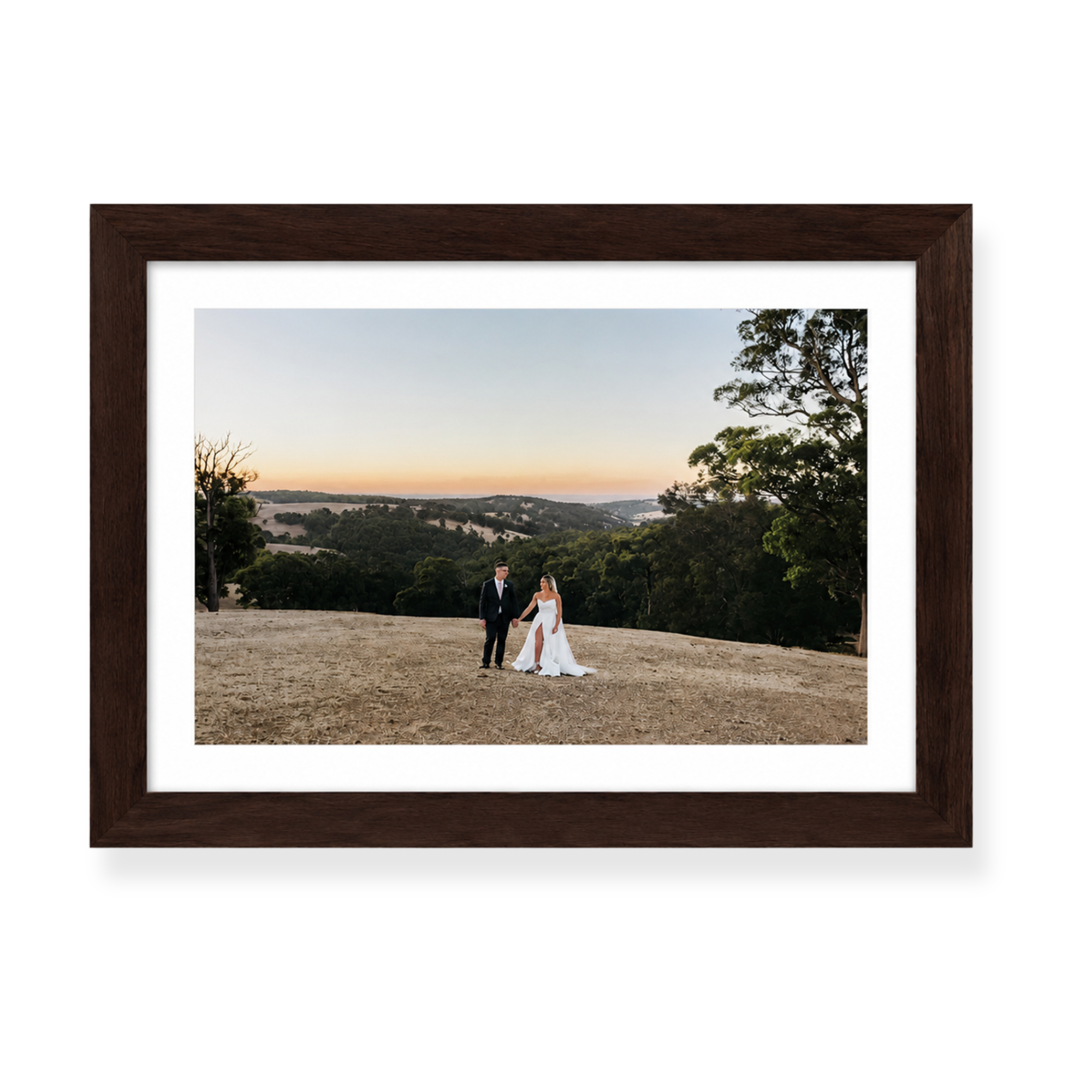 Framed wedding photograph print featuring a couple at sunset within a scenic Australian landscape.