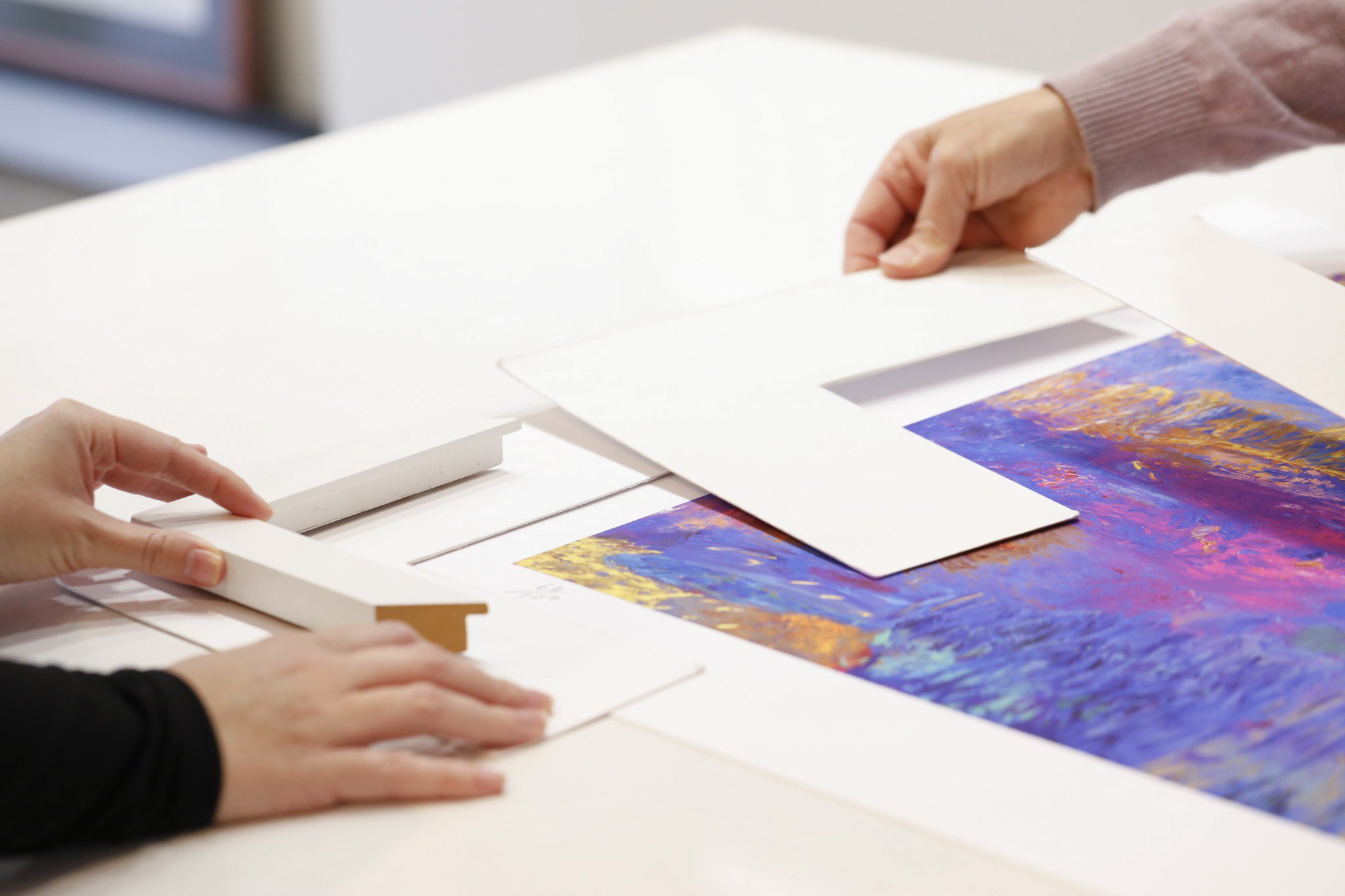 Custom framing consultation and archival matting preparation at Framed in Bunbury, WA. Professional framers carefully selecting mat board and frame materials for fine art, photography, and bespoke framing projects.