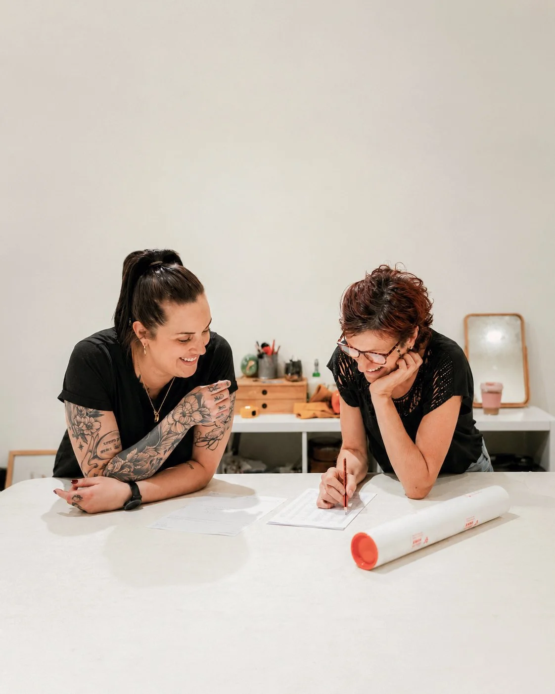 Two women collaborating on a framing project at Framed’s Bunbury studio.