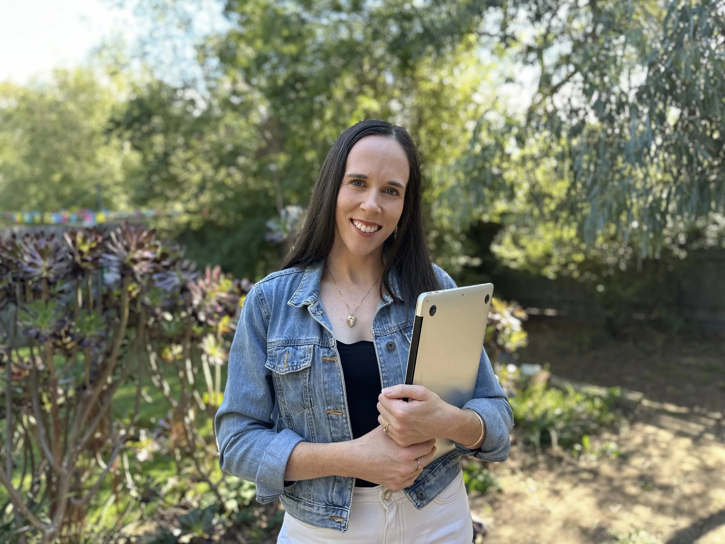 Melbourne copywriter and content writer Rachael Whitsed outside in Eltham with her laptop.
