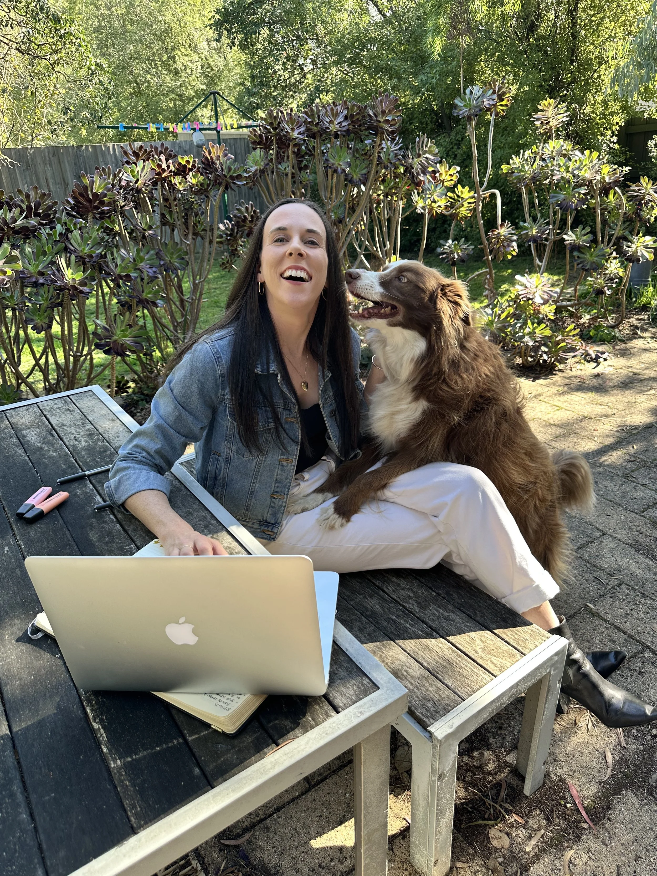 Melbourne copywriter and content writer Rachael Whitsed outside in Eltham with her laptop and dog.