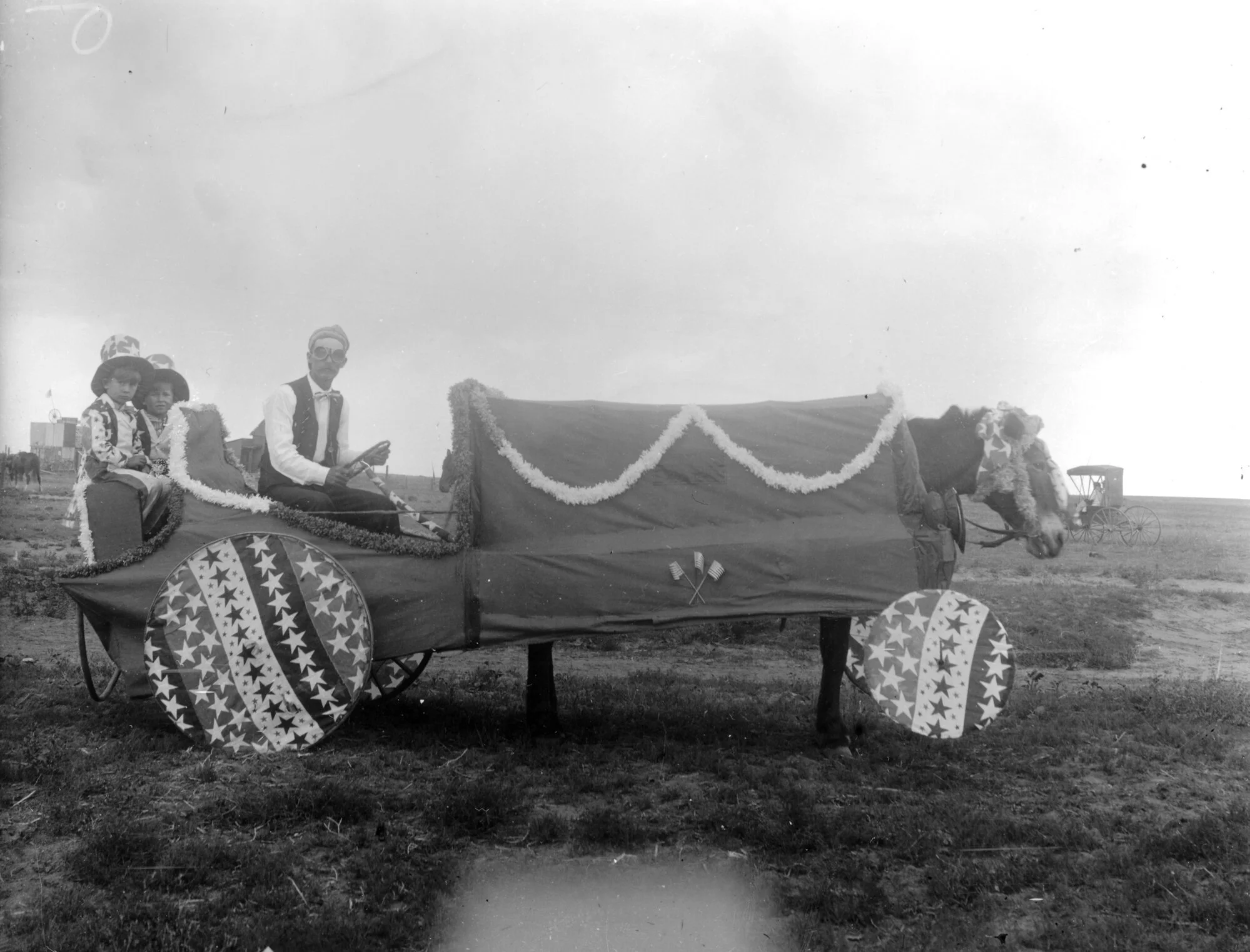A man, two children, and a horse are decorated for 4th of July in 1908 in Barr, Colorado
