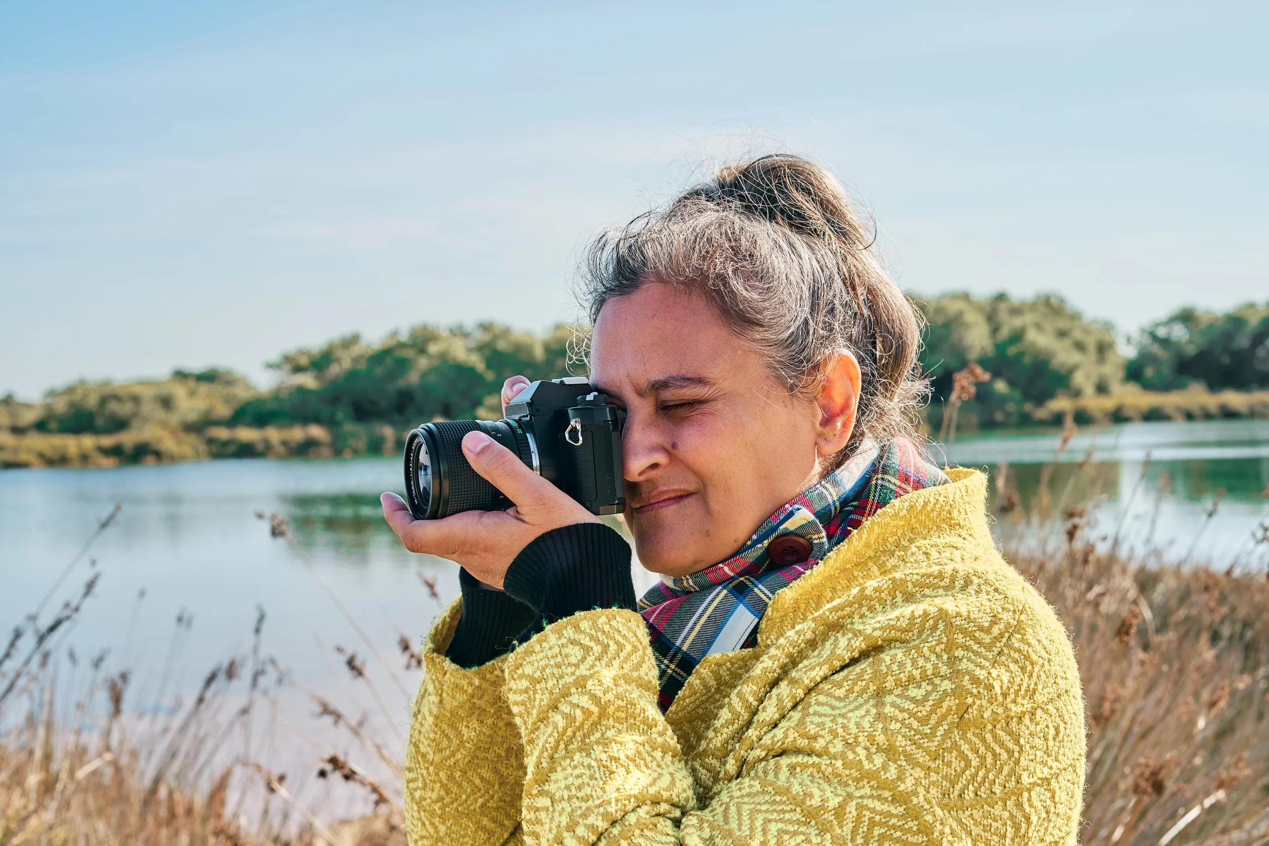 Woman holding camera taking photos outdoors