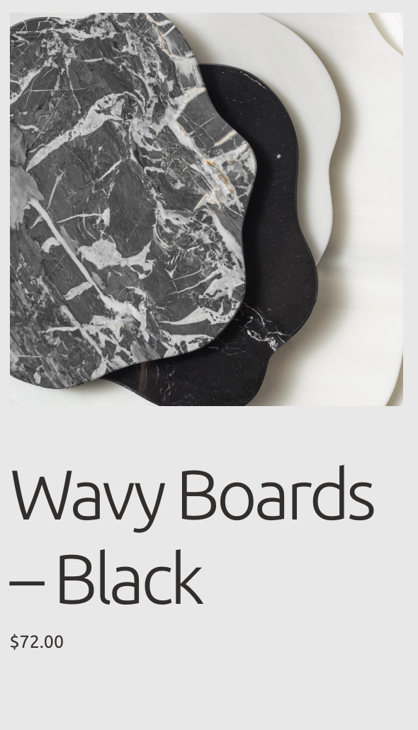 Three wavy-patterned boards in black, white, and gray marble designs stacked on top of each other against a gray background.