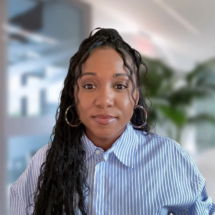 Tamoya Thomas, PMHNP-BC, smiling softly in a beige blazer and white shirt