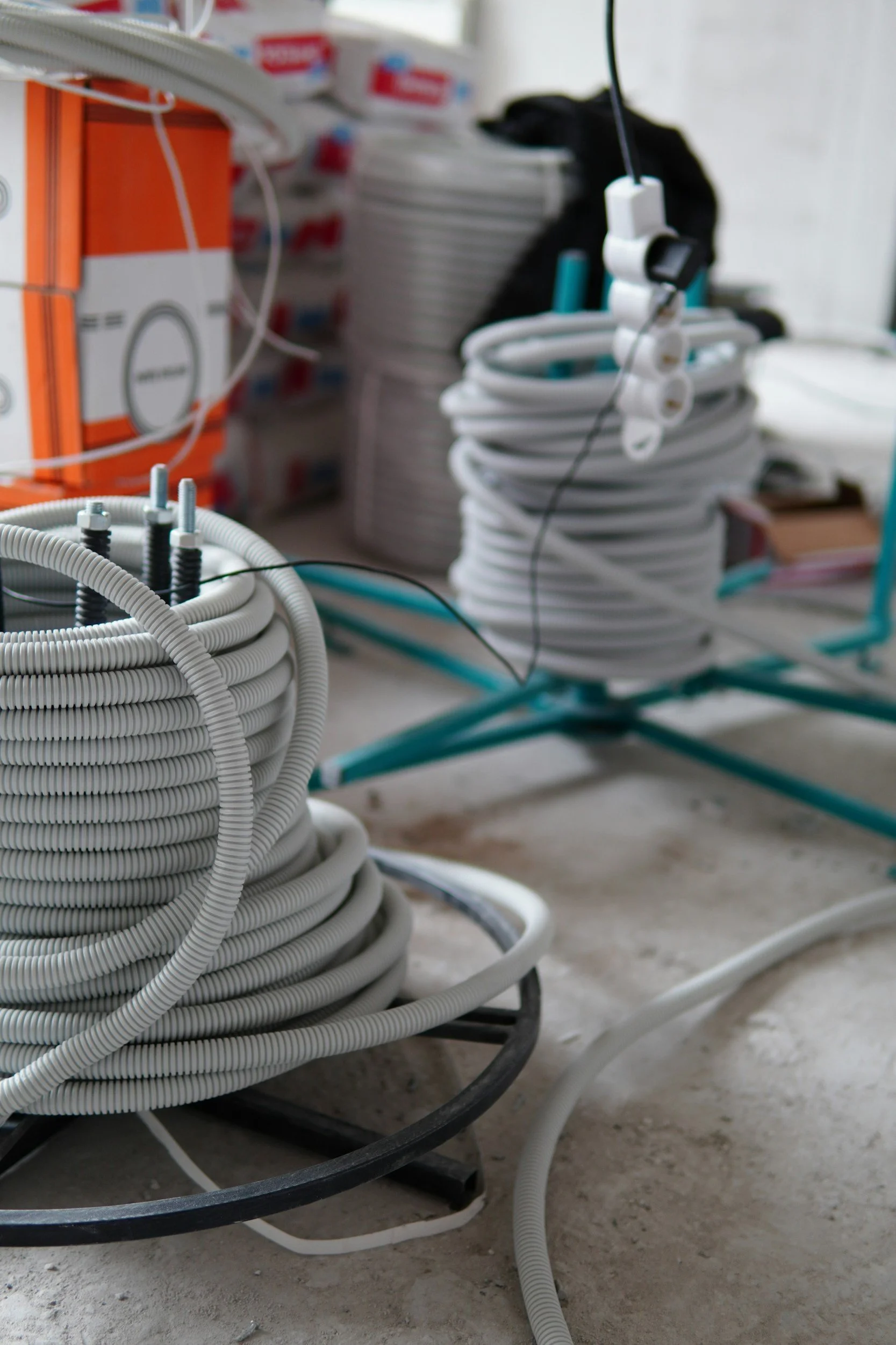 Spools of electrical conduit and wiring on a construction site.