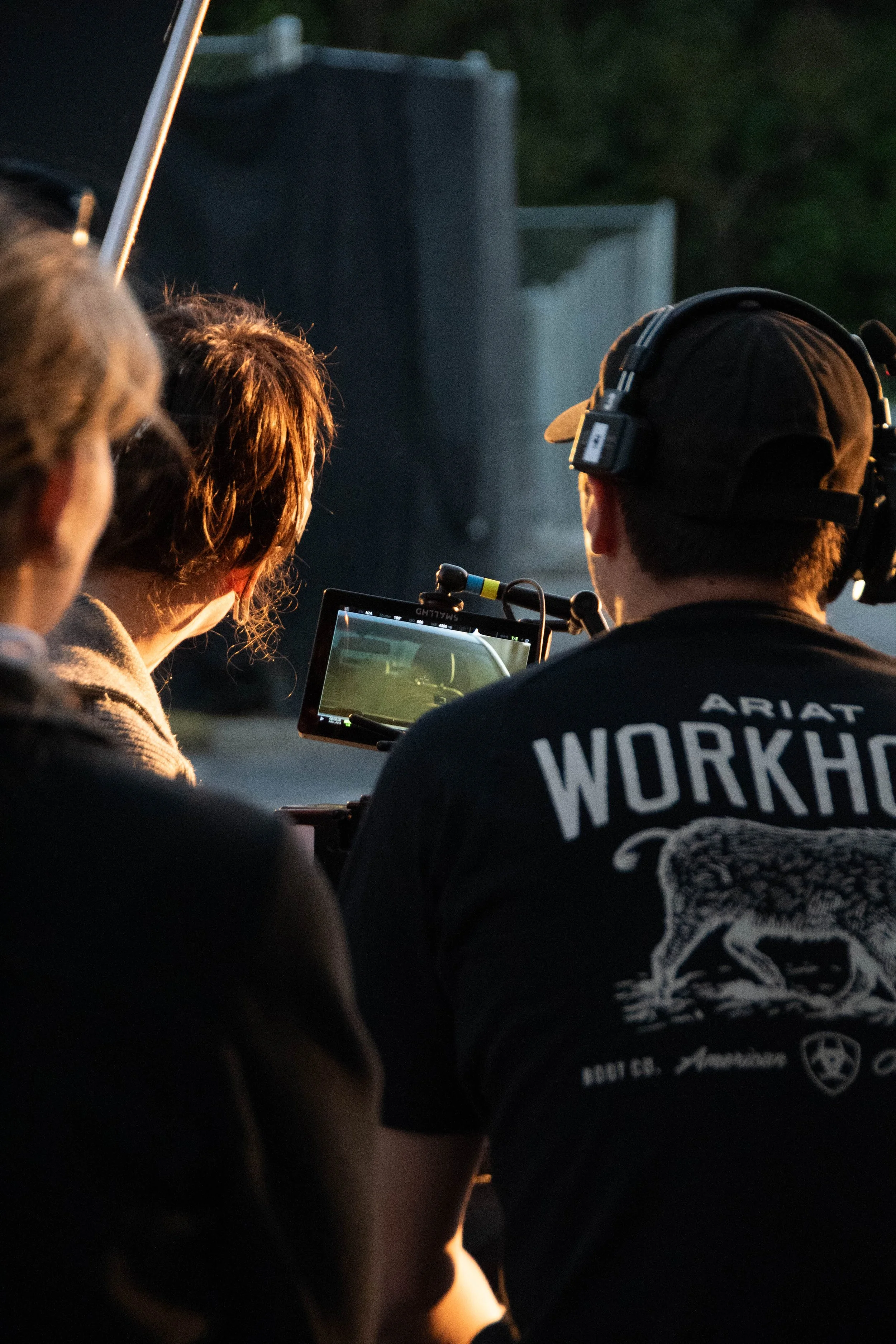 Crew members working with a camera on a film set during twilight.