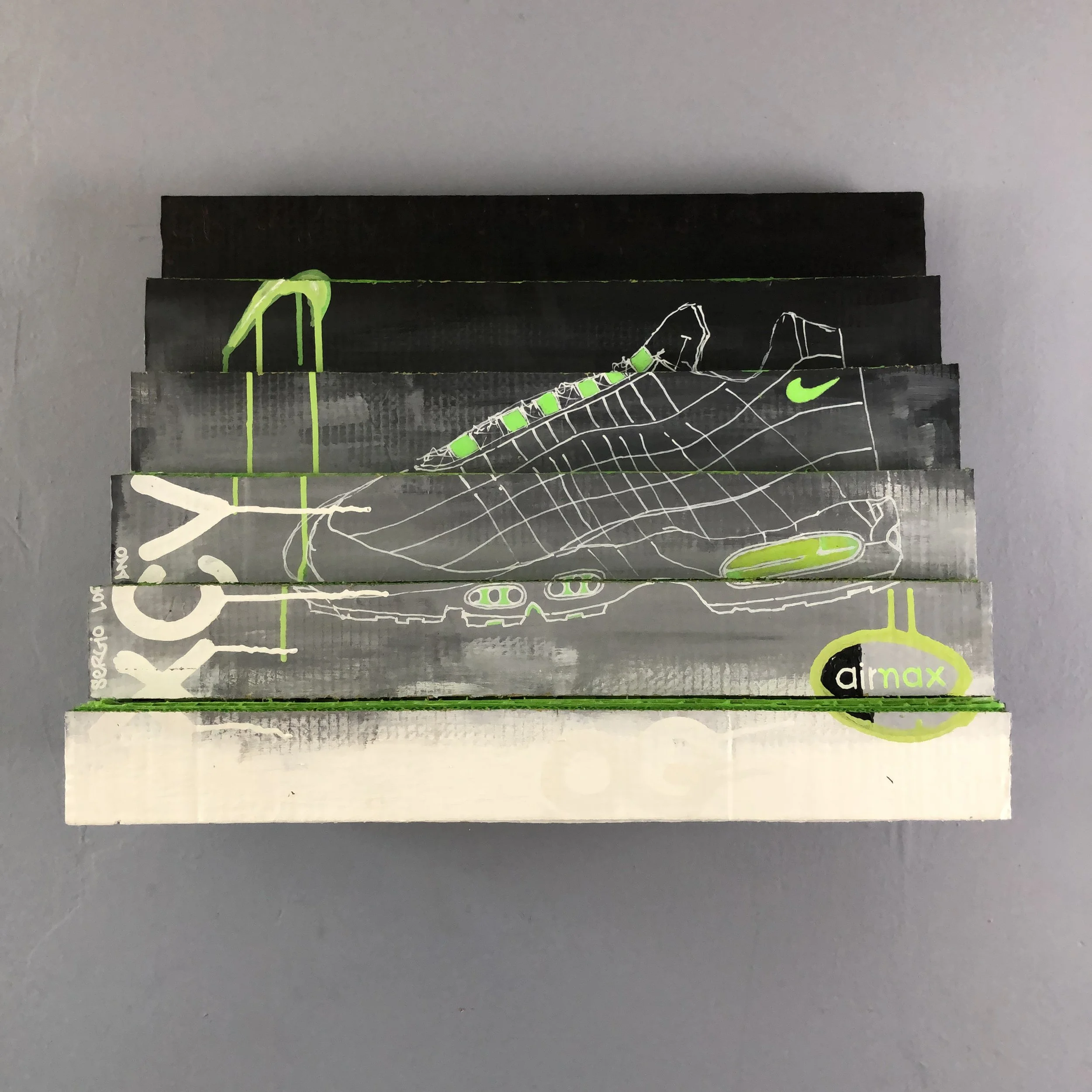 Rows of cardboard stacked horizontally at rising intervals covered in a greyscale color scheme and "AIRMAX 95" markings and "NIKE" logo's. Neon green accents replicating AIR MAX design color way.