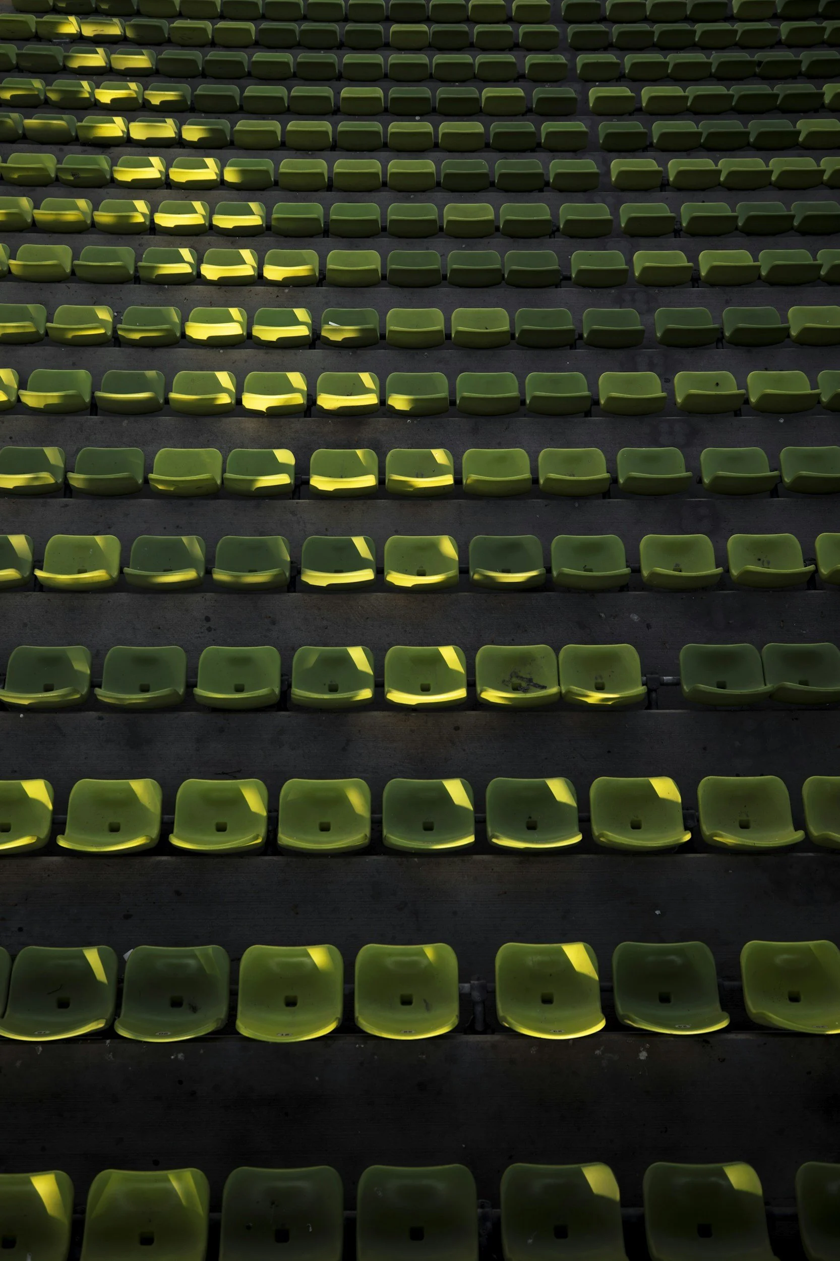 Picture of empty stadium seats with light pouring in.