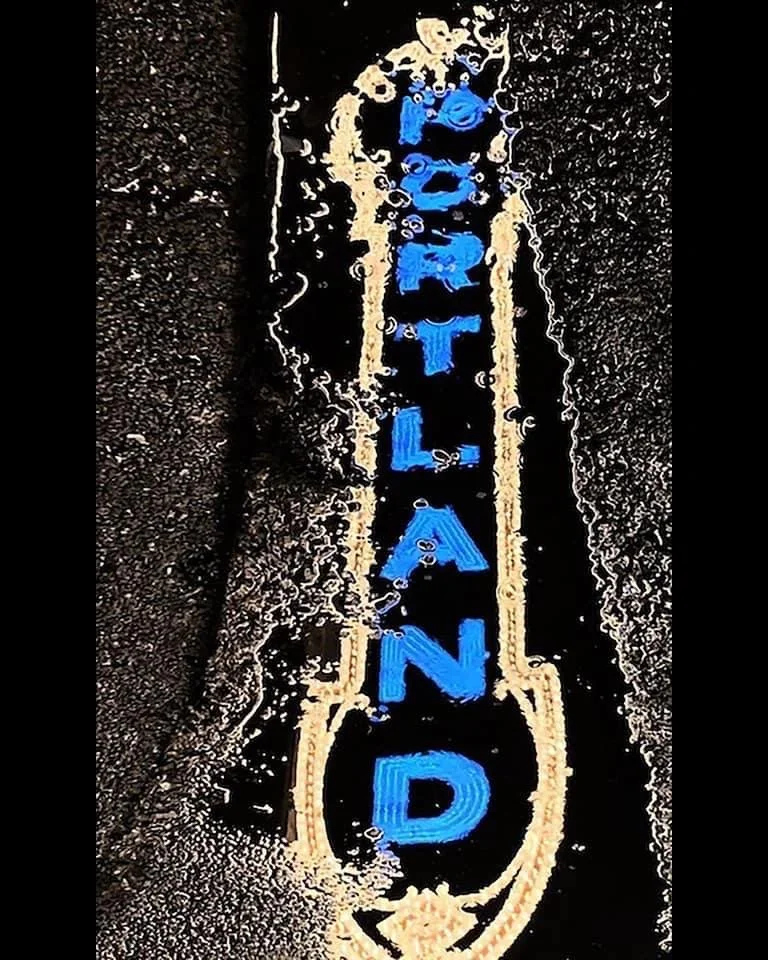 Neon sign reading 'TANDOOR' in blue letters outlined in orange, with a black background.