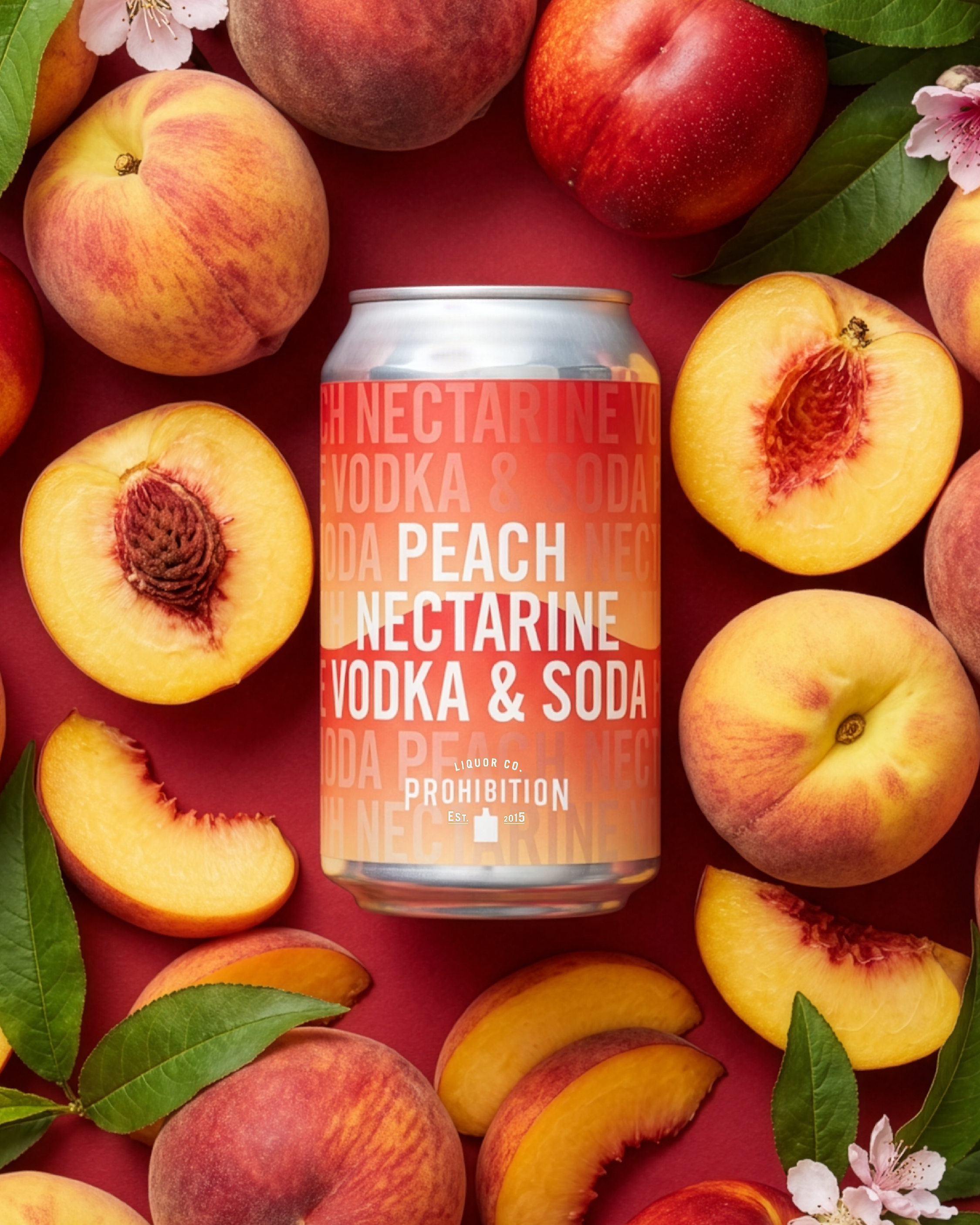 Cans of peach nectar drink surrounded by whole and sliced peaches and green leaves on a red background.