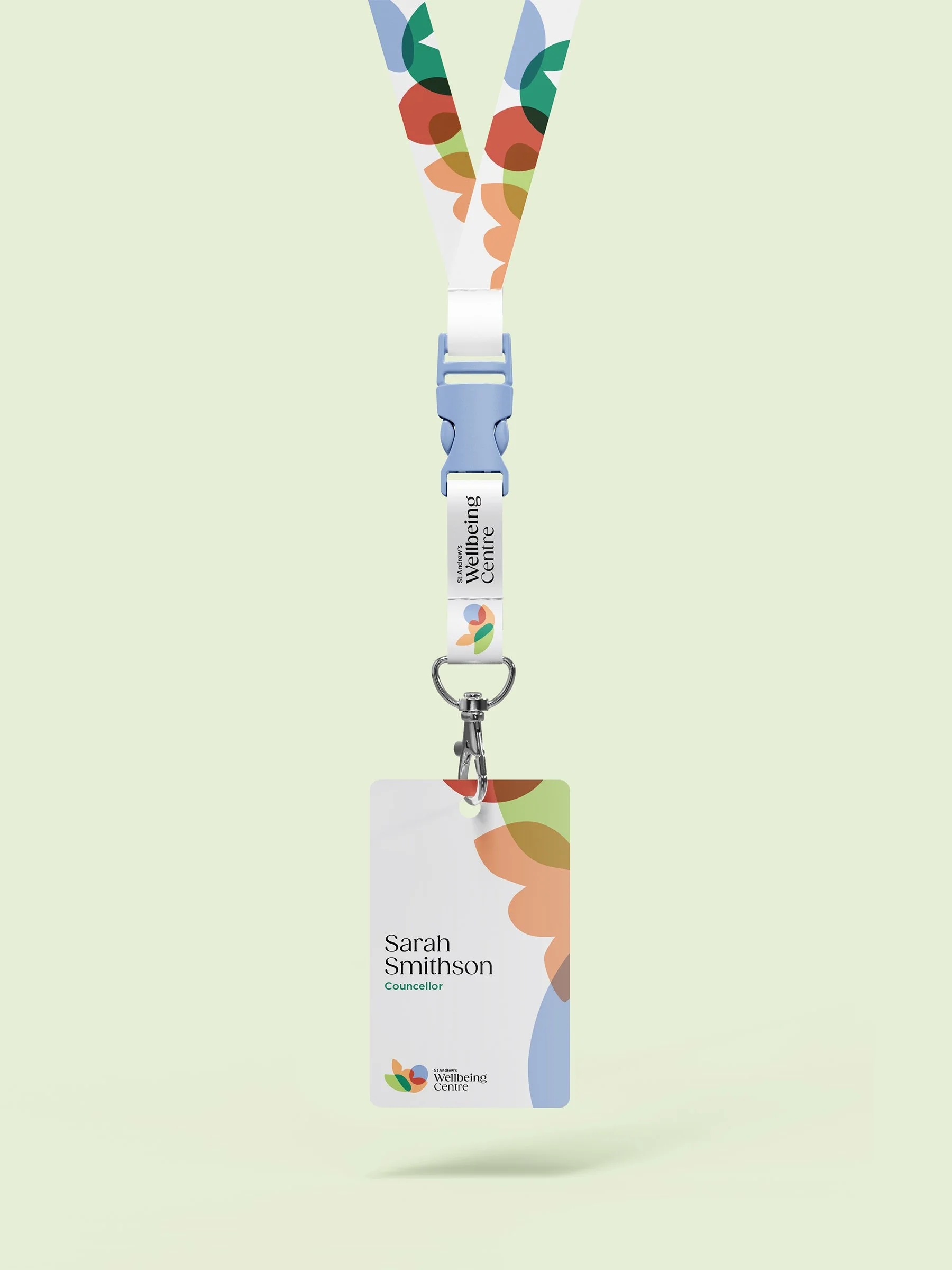 Name badge with colorful abstract design, displaying the name 'Sarah Smithson', the title 'Councillor', and the organization 'St. Andrew's Wellbeing Centre', attached to a lanyard with the same design.