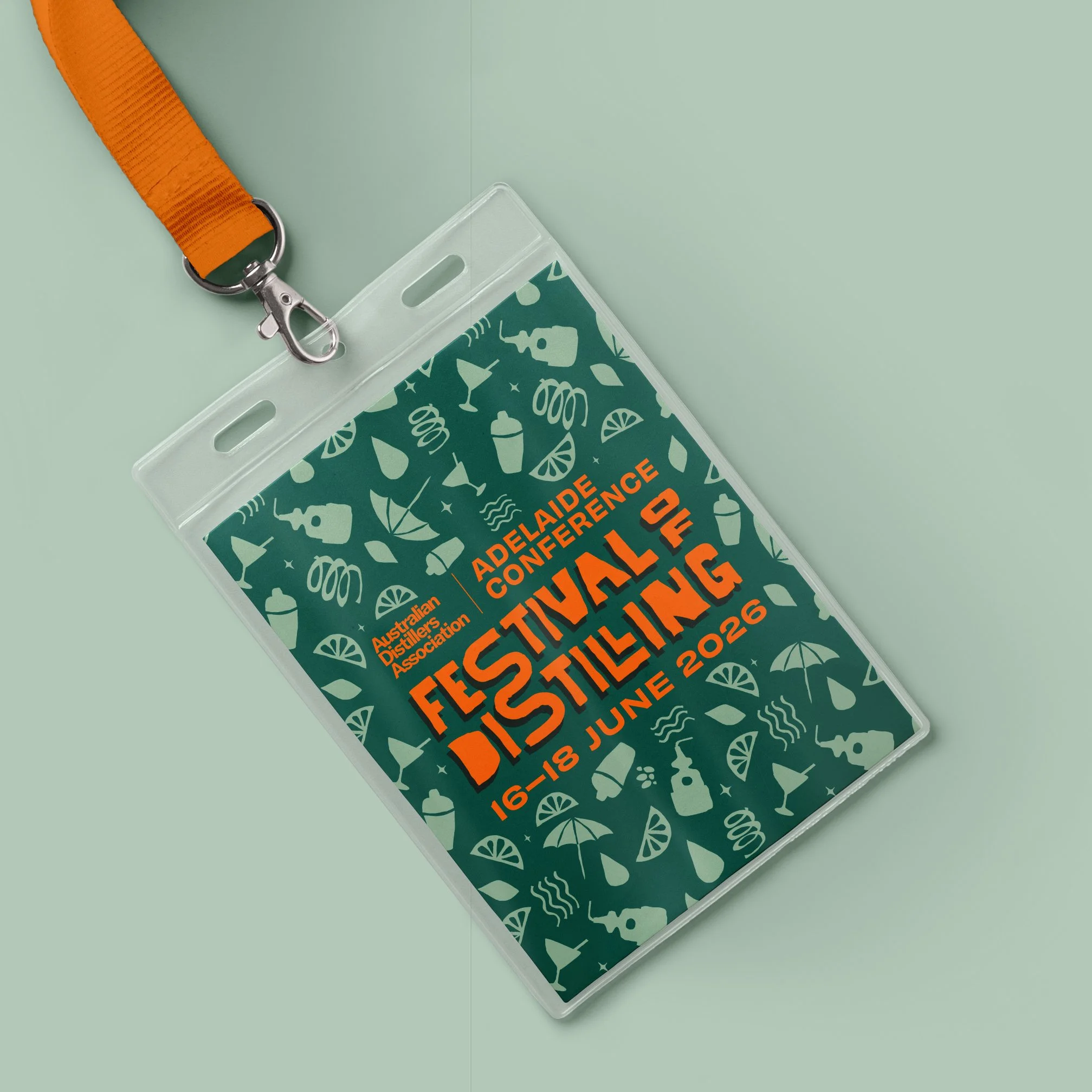 Conference badge with orange neck strap, partially visible text, and festive graphics on a dark background.