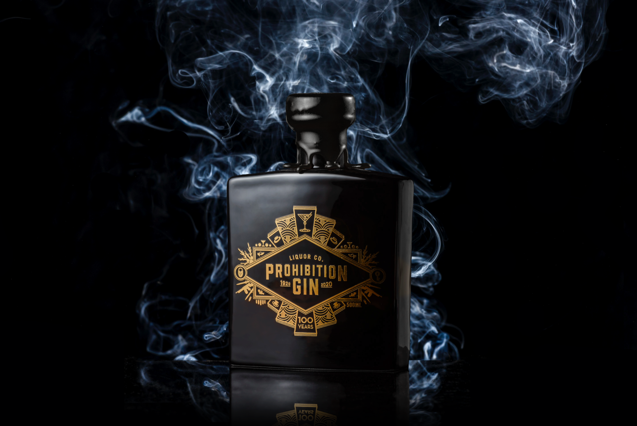 A black bottle of Prohibition Gin with gold label branding, surrounded by swirling blue and white smoke, against a black background.