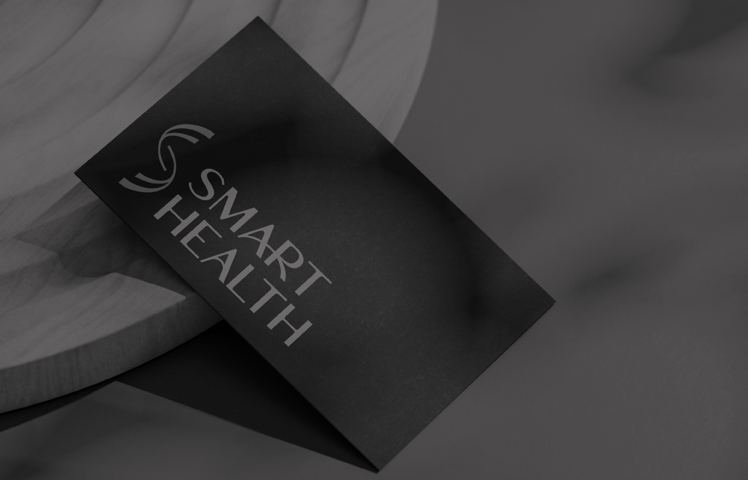 Close-up of a black paper with white text, reading 'SMART HEALTH' on a wooden surface.